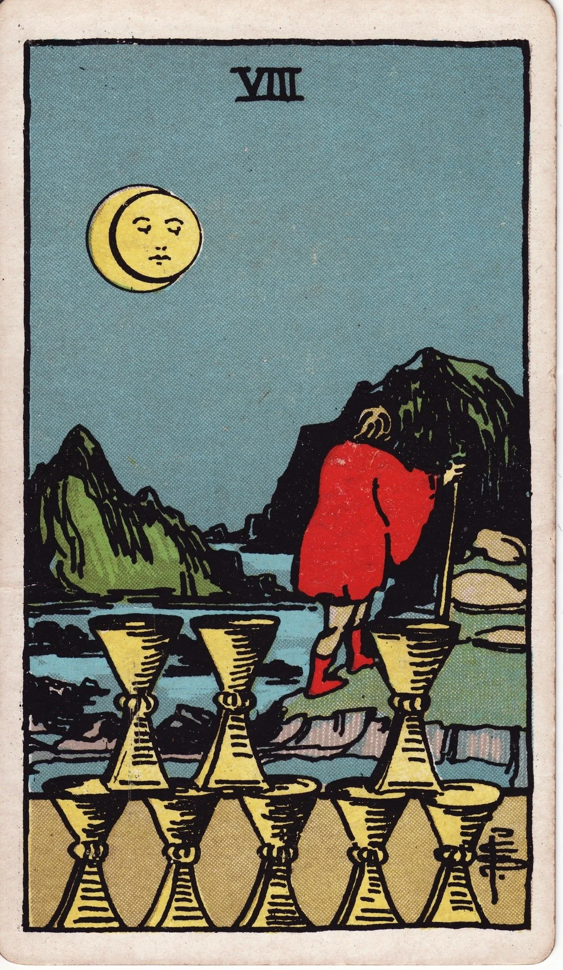 The Tarot card The Moon showing a figure walking away with a staff, near three cups and a mountain landscape with a moon in the night sky.