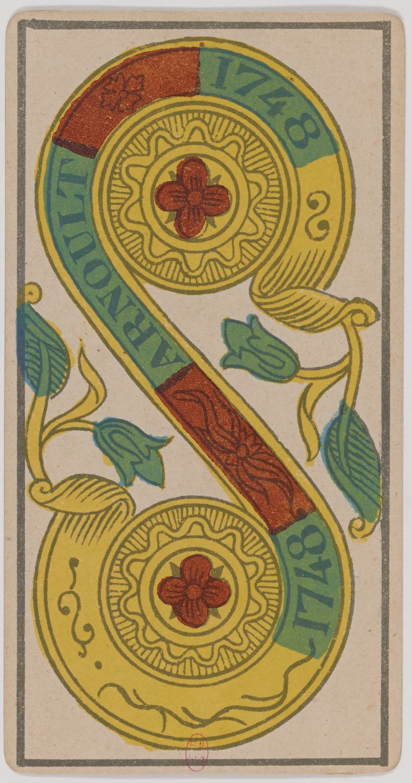 Vintage playing card back design with a large ornate letter 'S' and floral patterns.