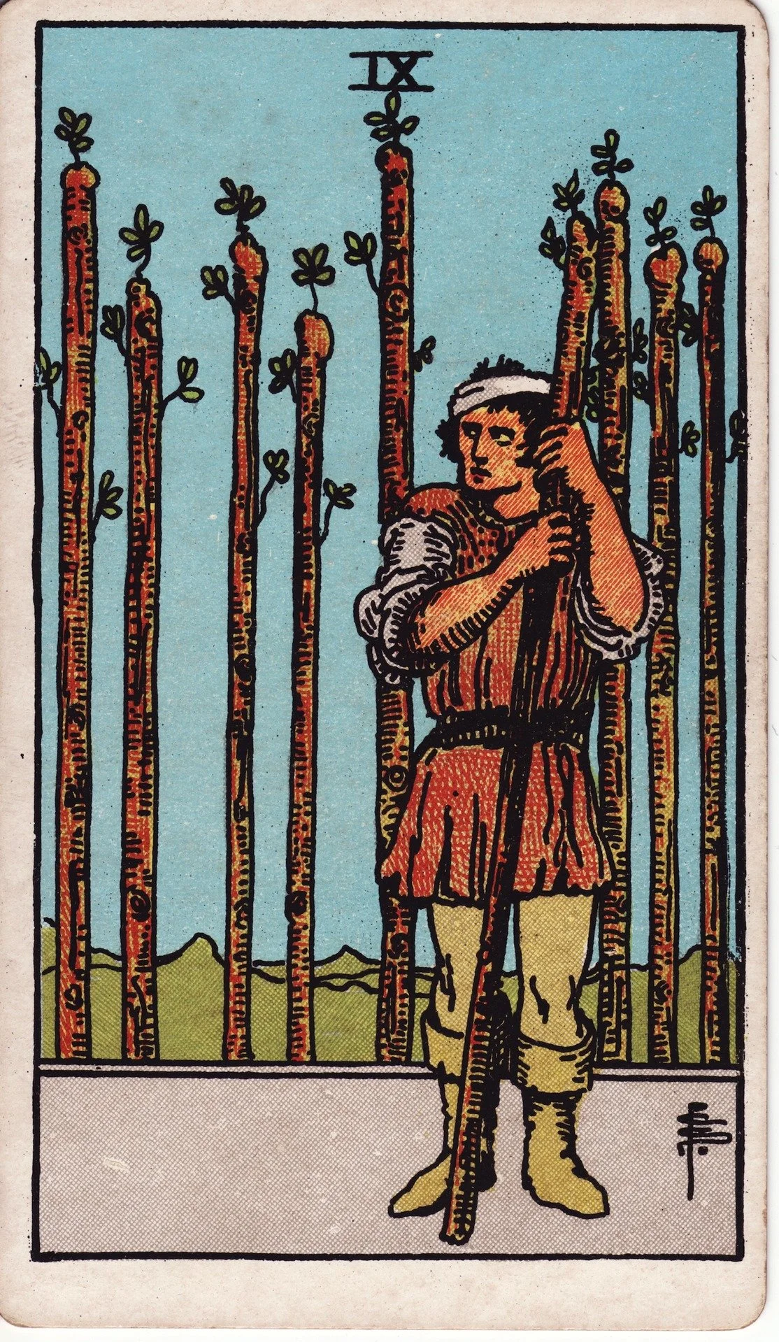 The Two of Wands tarot card featuring a man standing outdoors, holding a staff, with a backdrop of a landscape and a row of trees.