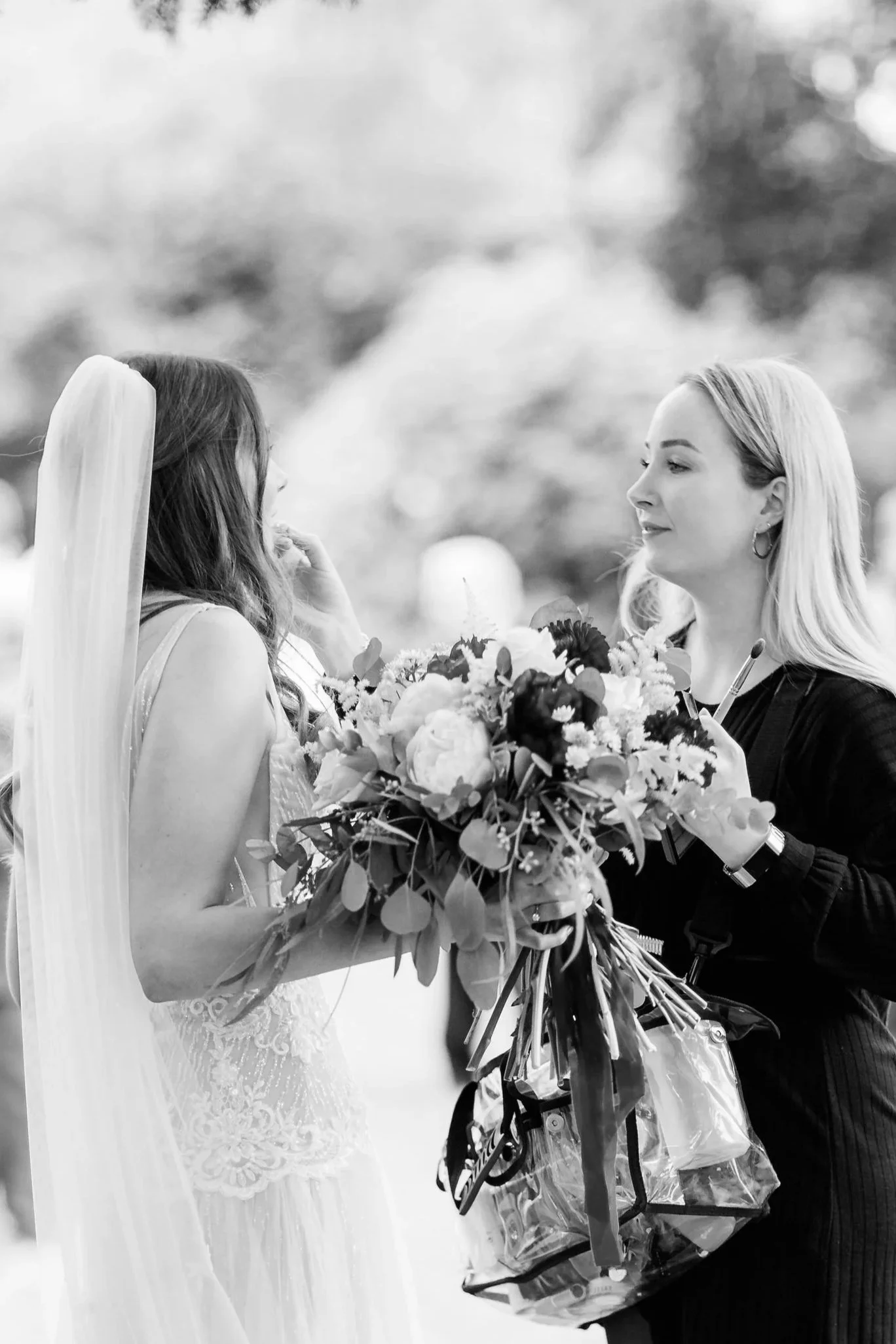 Bride getting makeup touched up during wedding at Garthmyl hall wedding venue in powys near welshpool