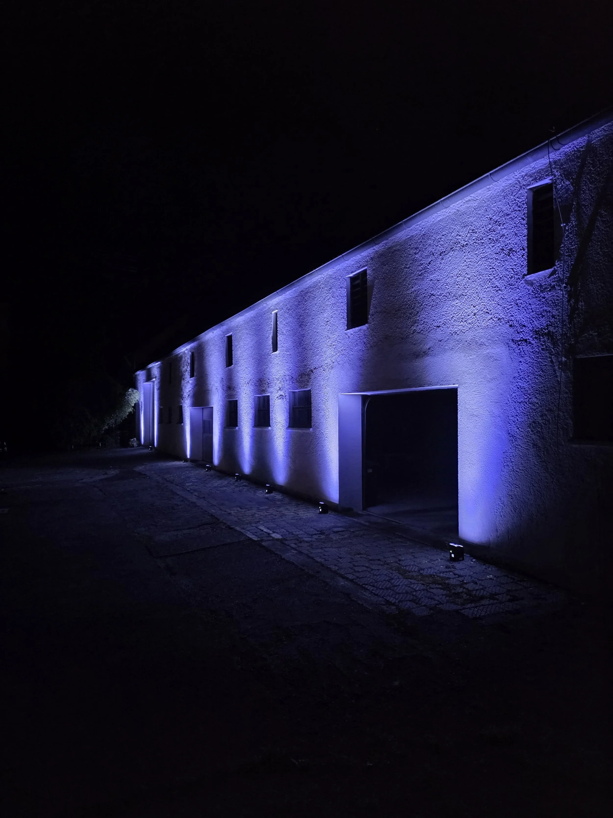 Two blue LED lights illuminating a textured wall.
