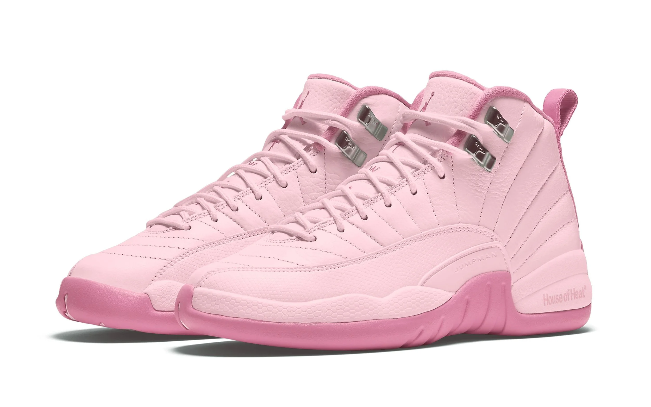 A pair of light pink high-top athletic shoes with silver eyelets and textured soles.