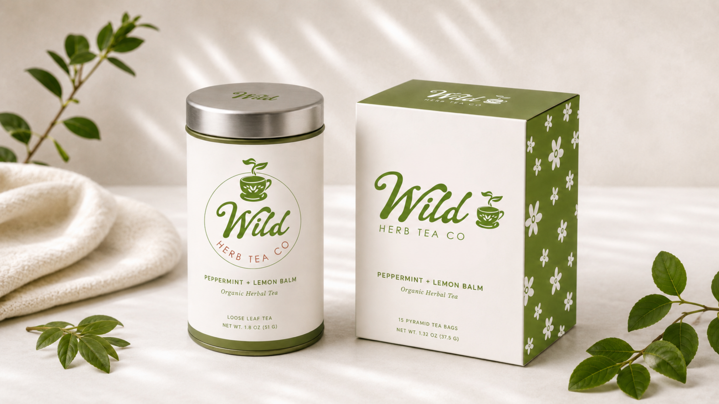 A container and a box of Wild Herb Tea Co peppermint and lemon balm herbal tea, with green leaves and a beige cloth nearby.