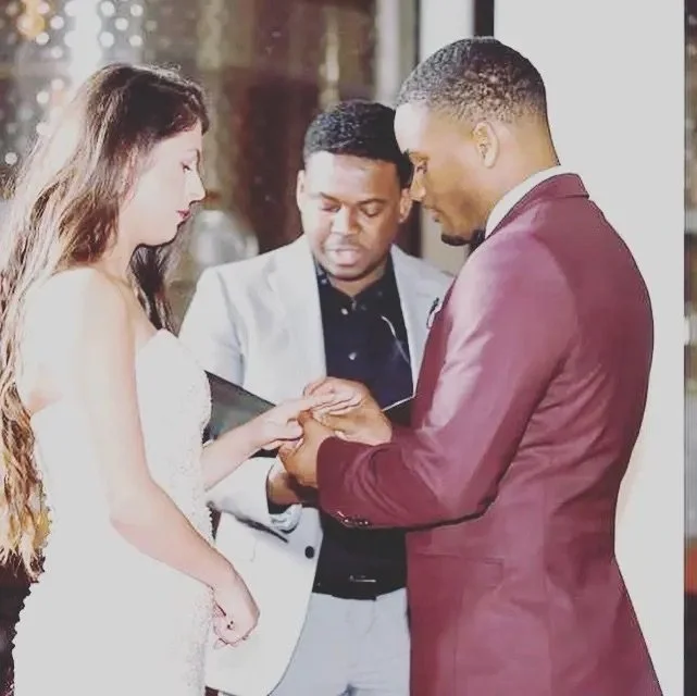 A couple getting married during a wedding ceremony, with an officiant present.