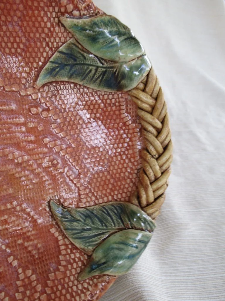 Decorative ceramic leaves on a woven basket surface.