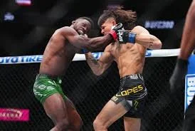 Two male mixed martial arts fighters in a cage, one throwing a punch while the other blocks.