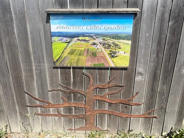Finnriver Farm & Cidery painted sign and bas relief tree outside of building