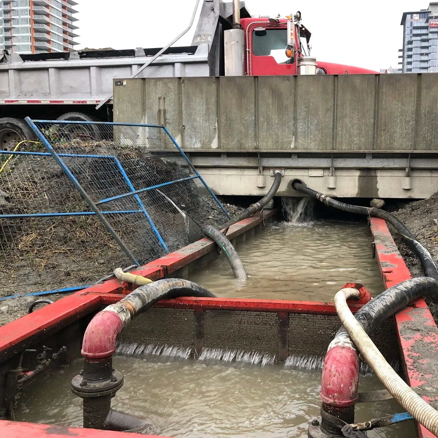 Construction site with a wheel wash to prevent track-out of contaminated soils.  Dirty water being recirculated with pumps and pipes, will add coagulant and flocculant to clarify this water inside the existing equipment for reuse in the system.