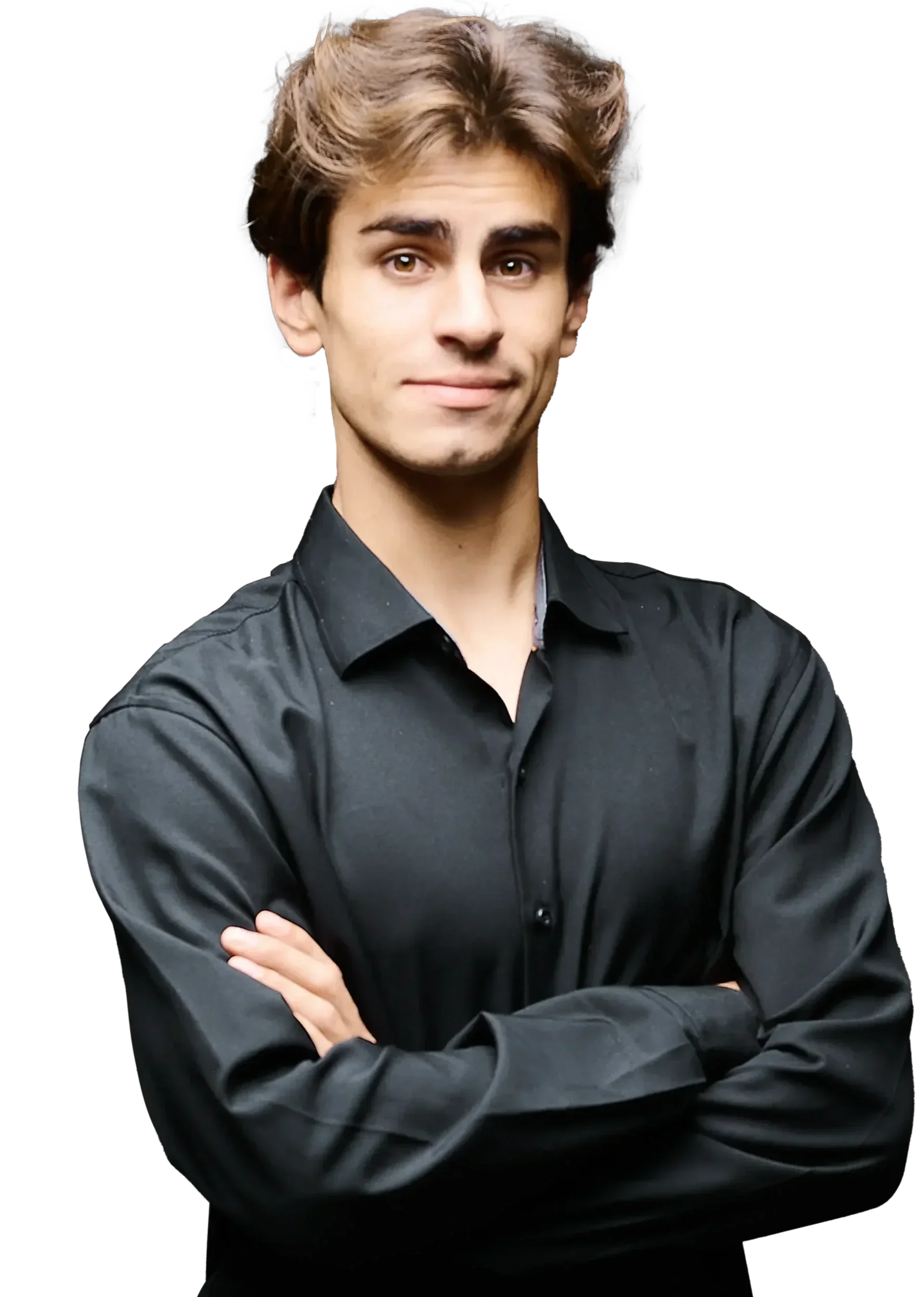 Young man with brown, wavy hair, wearing a black, long-sleeved, button-up shirt, standing with arms crossed against a black background.