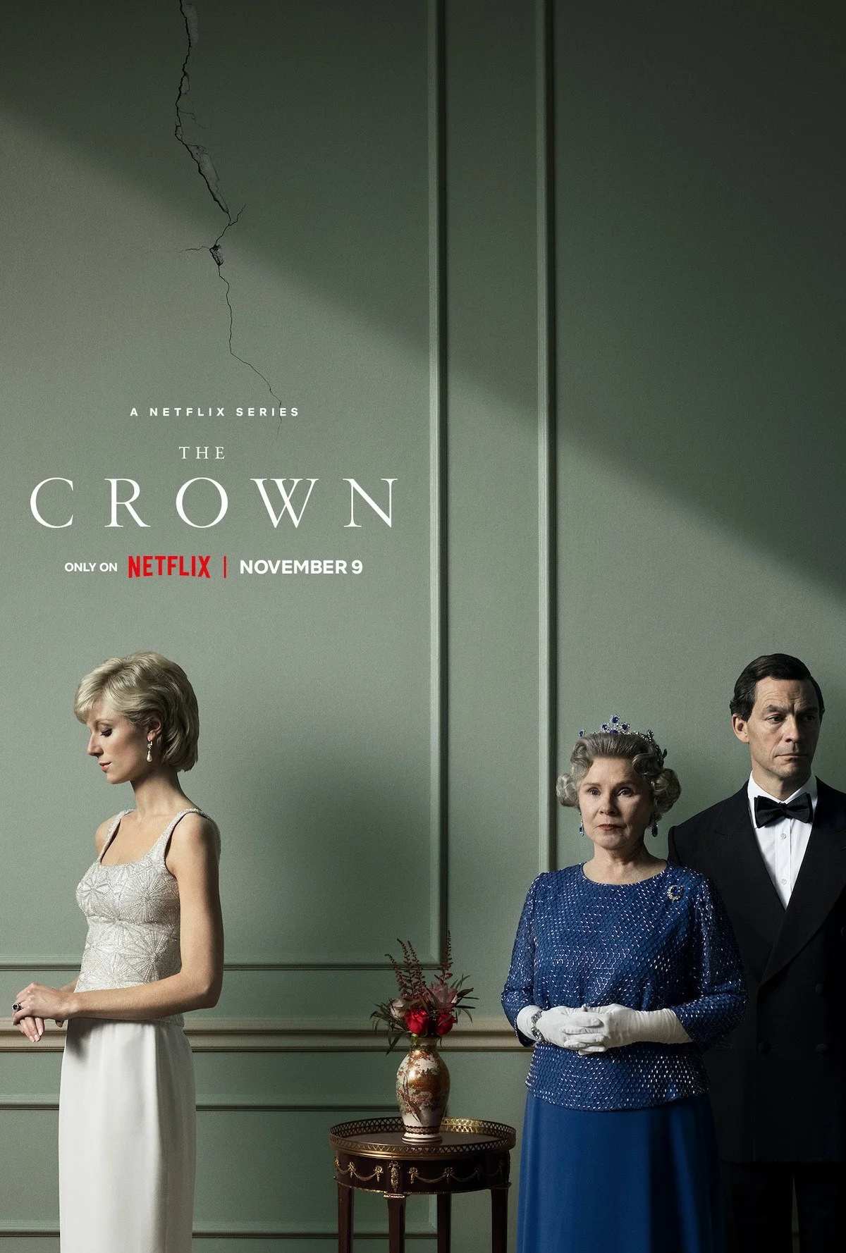 Promotional poster for the Netflix series 'The Crown,' showing three characters dressed in formal attire in a tastefully decorated room, with a cracked wall on the upper left, and text indicating the series release date of November 9.