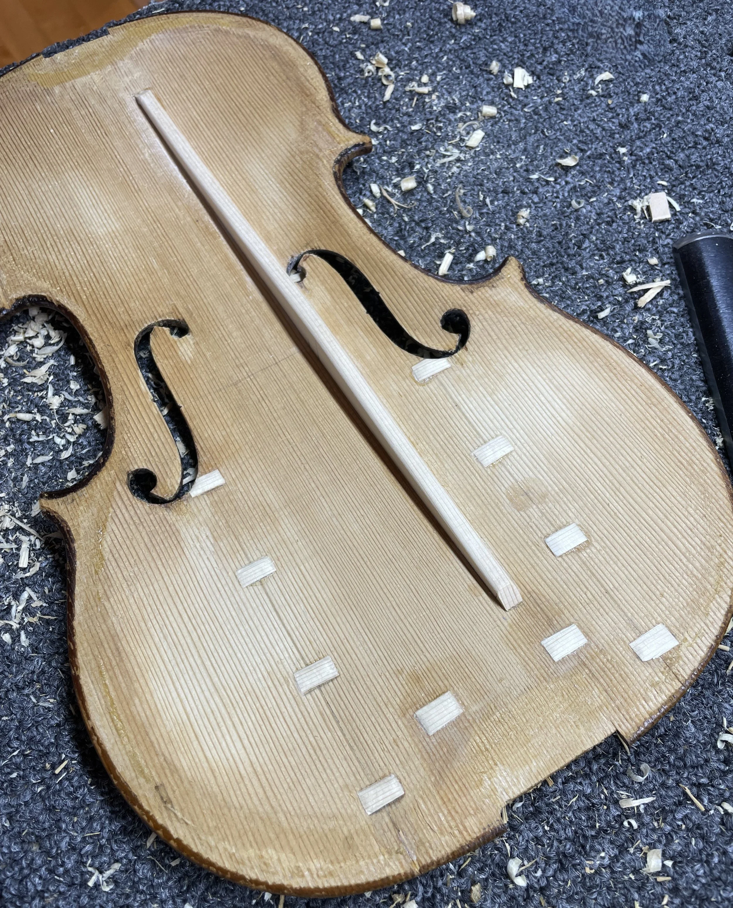 Repaired violin top plate with cleats and newly fit bass bar.