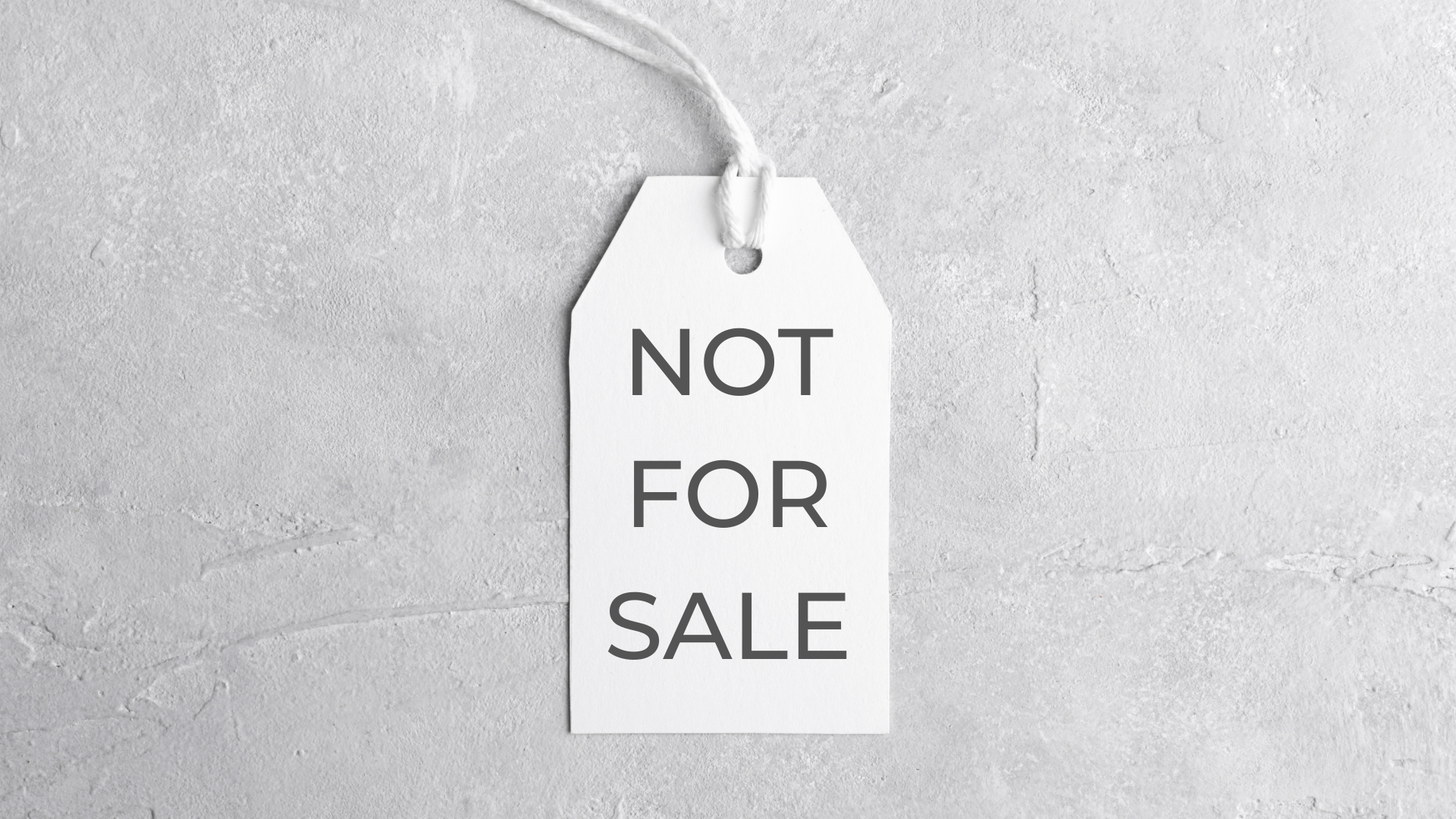 White tag with the text 'NOT FOR SALE' hangs from a piece of white string against a plain white textured wall.
