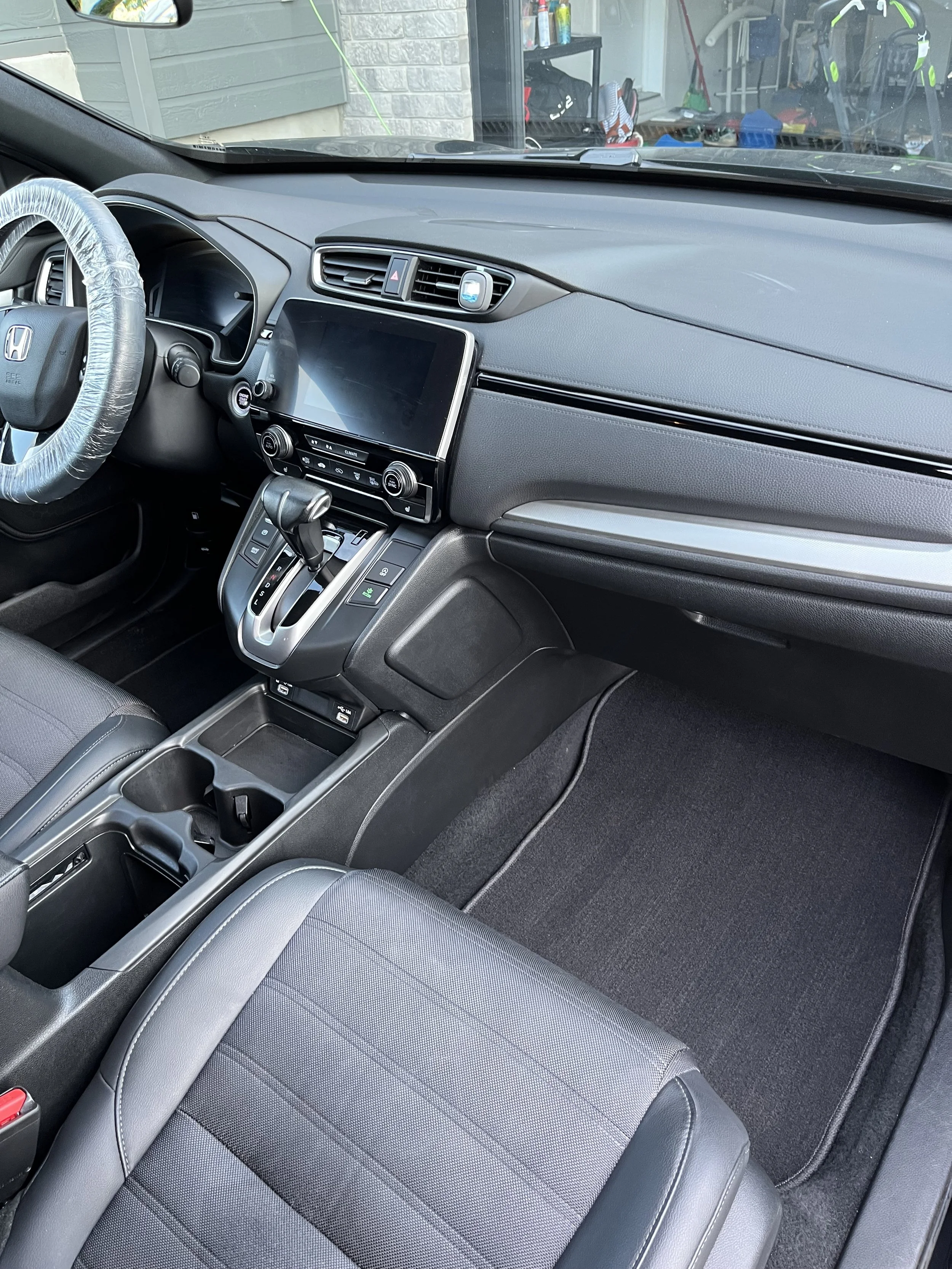 L'intérieur d'une voiture Honda avec tableau de bord, volant, écran tactile, levier de vitesses et console centrale.