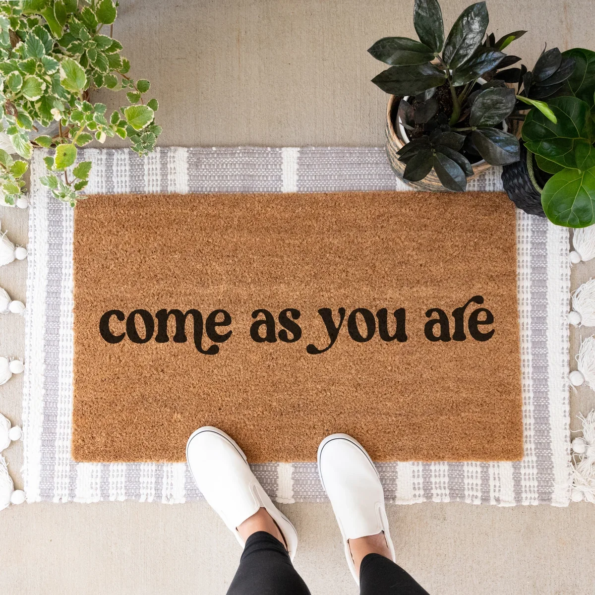 Doormat that reads "Come as You Are" with feet standing on it.