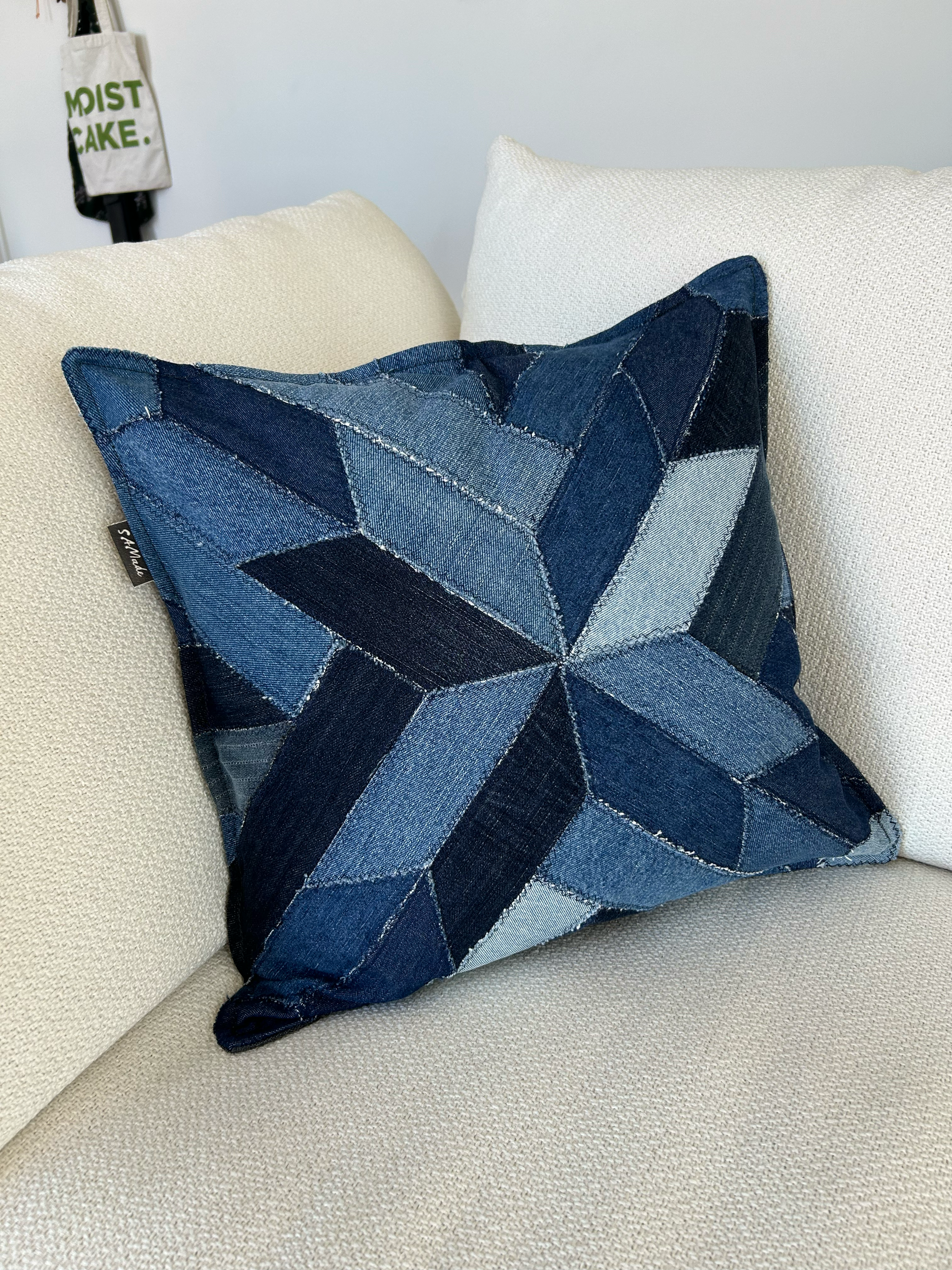 Throw cushion cover made from upcycled denim jeans and reclaimed blackout fabric. Insert made from retired pillowcase stuffed with fabric off-cut scraps.