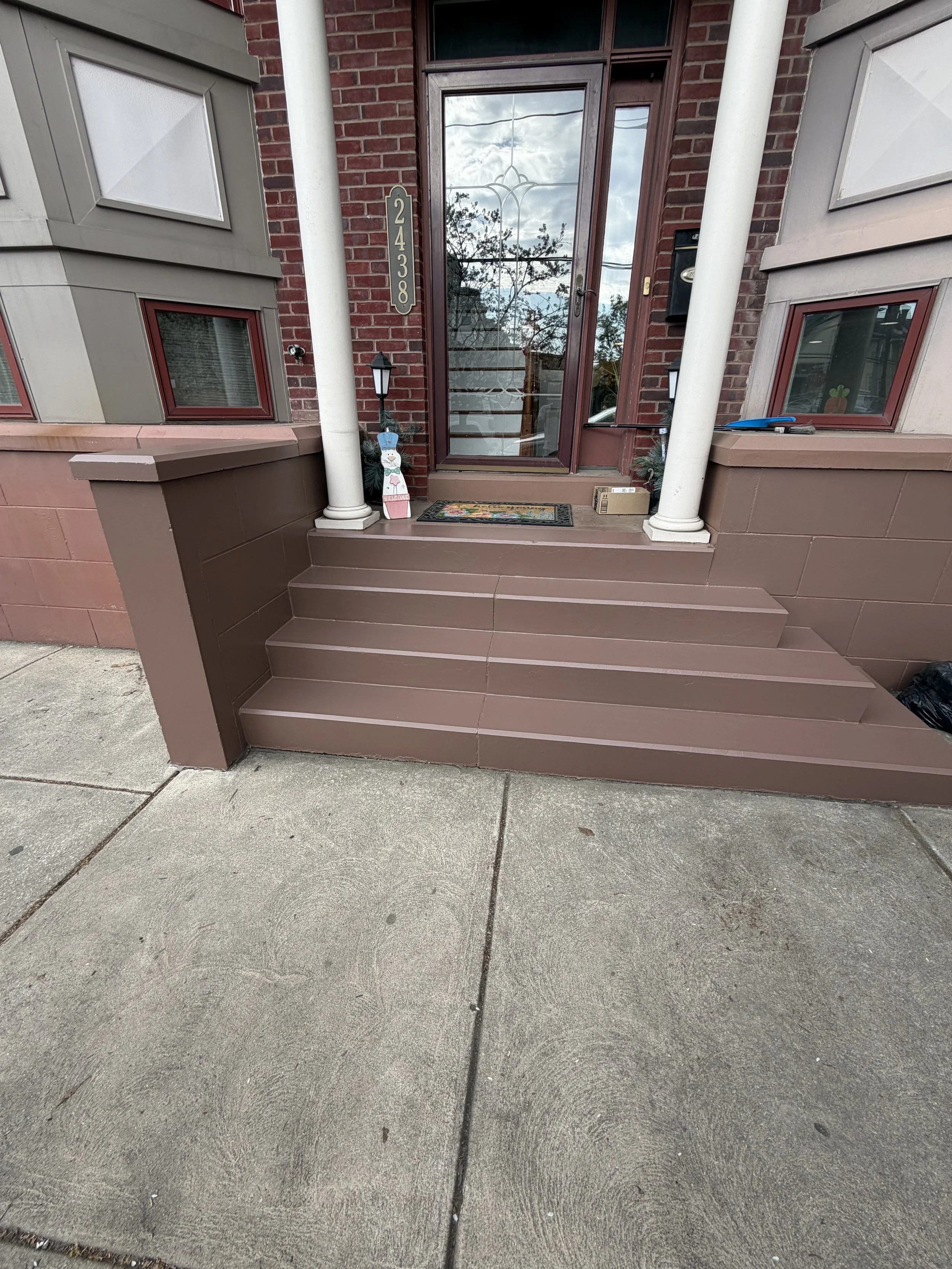 Exterior painting project featuring painted front steps, columns, and entryway