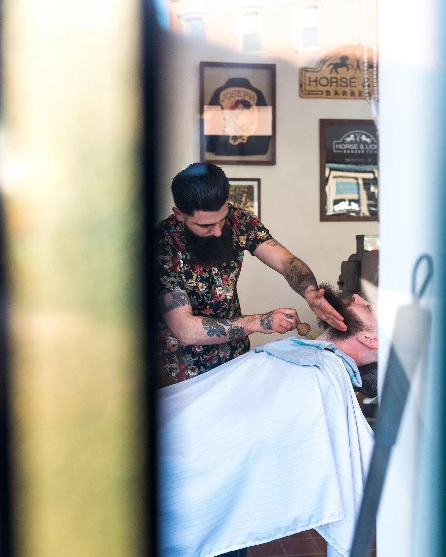 Owner Ian Napoli working on a beard shave for a customer at Horse and Lion Barbershop Co.