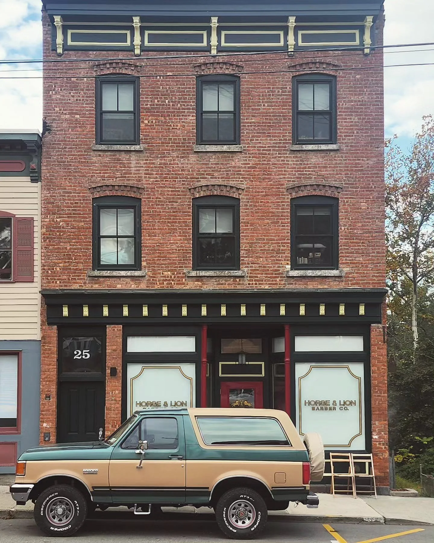 Exterior of Horse and Lion Barber Co with a classic Chevy Wagon parked in front