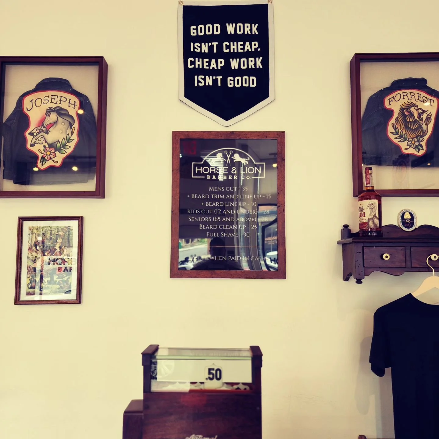 Wall decor at Horse and Lion Barber Co. including news articles, leather jackets, and framed artwork