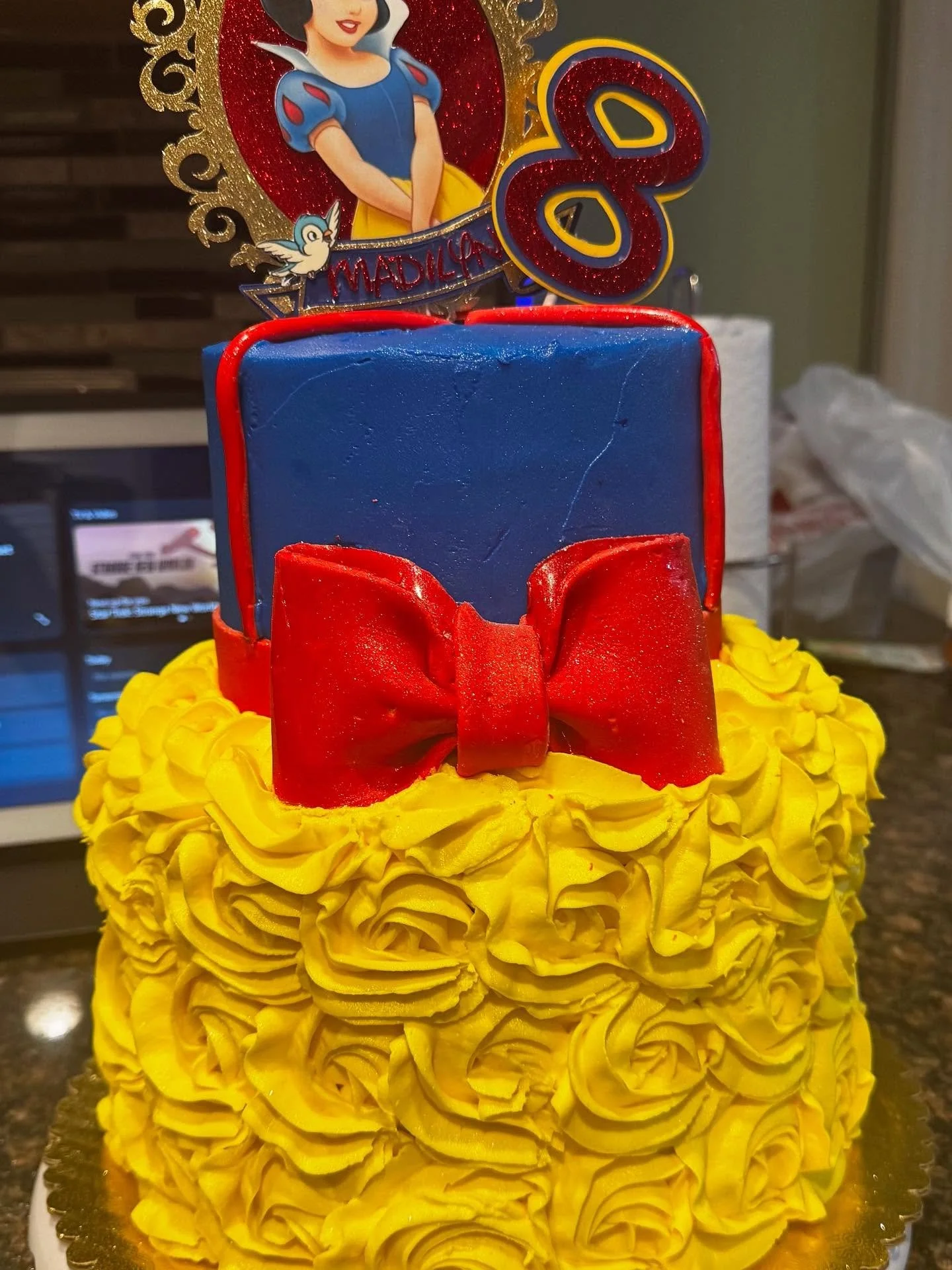 Snow White birthday magic! 🍎✨ A royal cake with golden buttercream rosettes, a bold red bow, and the perfect pop of princess charm