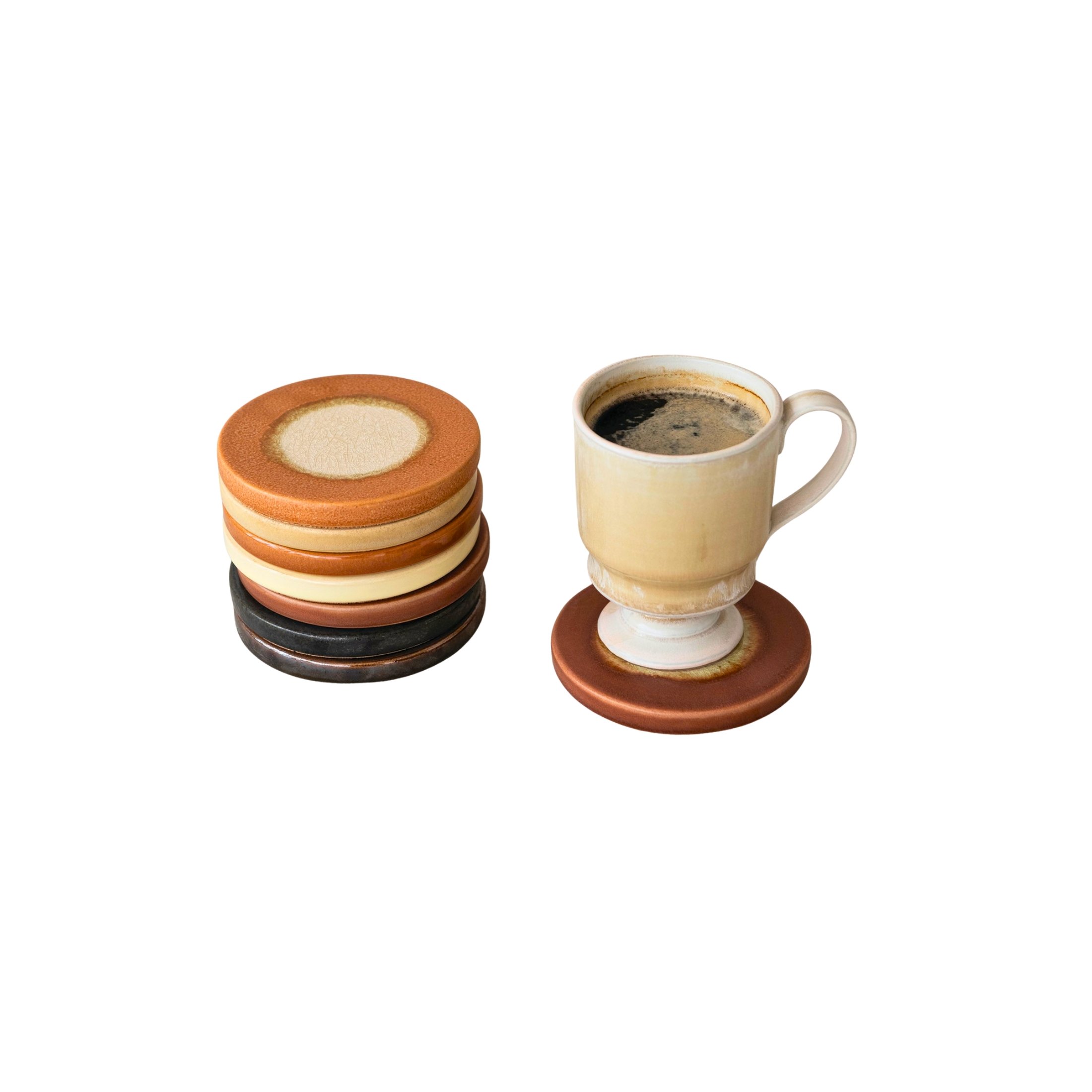 Stack of glazed stoneware coasters beside a coffee mug