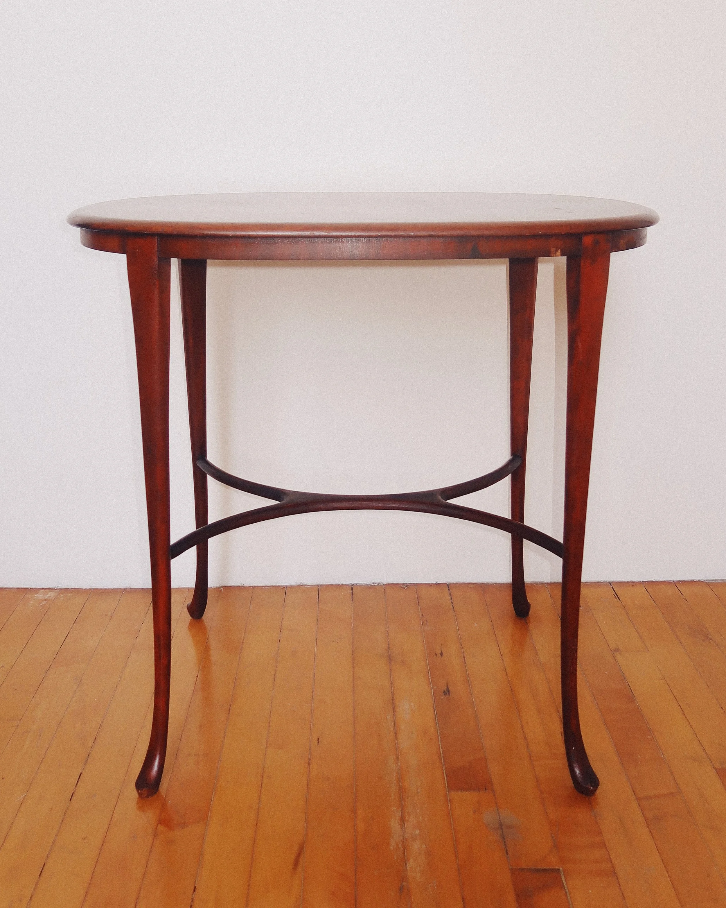 1930s Queen Anne-style oval mahogany side table with cabriole legs and X-stretcher base.