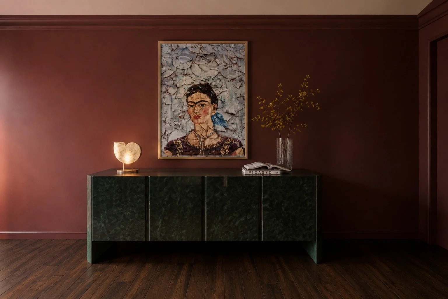 Interior with a dark green cabinet, framed portrait painting of a woman with short curly black hair and jewelry, a glowing lamp shaped like revolved stone, a vase with yellow flowers, and books including one titled 'PICASSO' on a dark wooden floor an