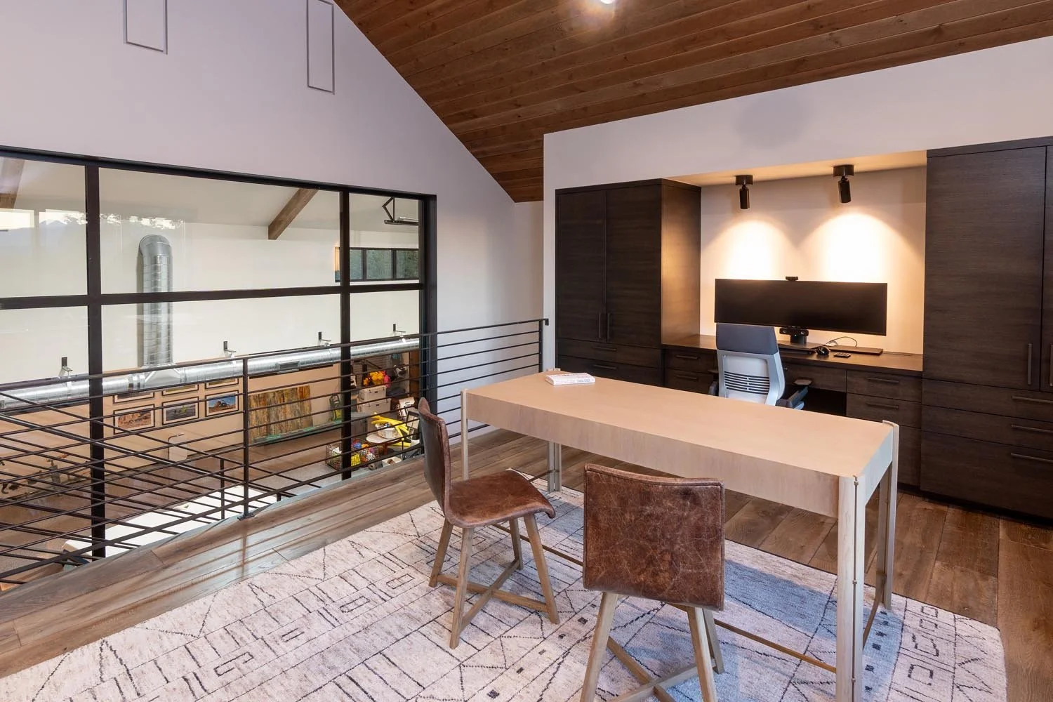 This sophisticated modern home office at Pacific Cascade Heights is a perfect blend of productivity and unique design, a testament to the masterful interior design by Kate Darden. The workspace features a sleek wooden desk and a dark wood built-in wa
