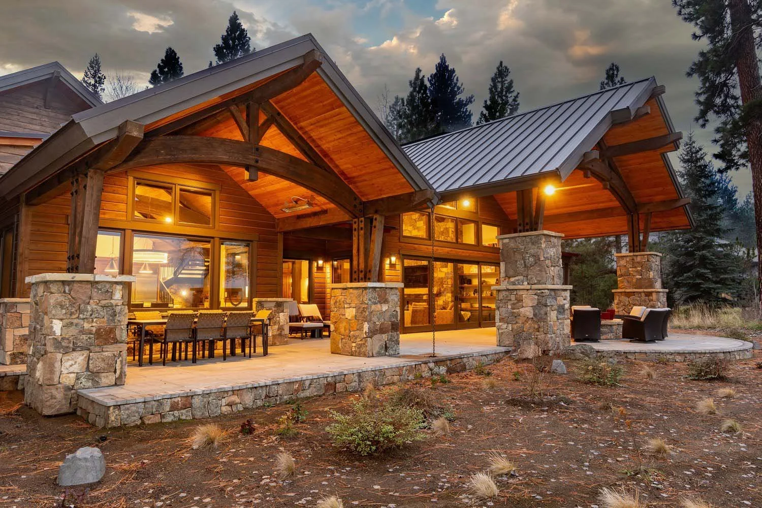 This captivating exterior view of the Black Butte Ranch - Bishops Cap home, designed by Spencer Williams at Pacwest Builders, showcases its classic mountain modern design against the backdrop of a Central Oregon. The home features a welcoming stone a
