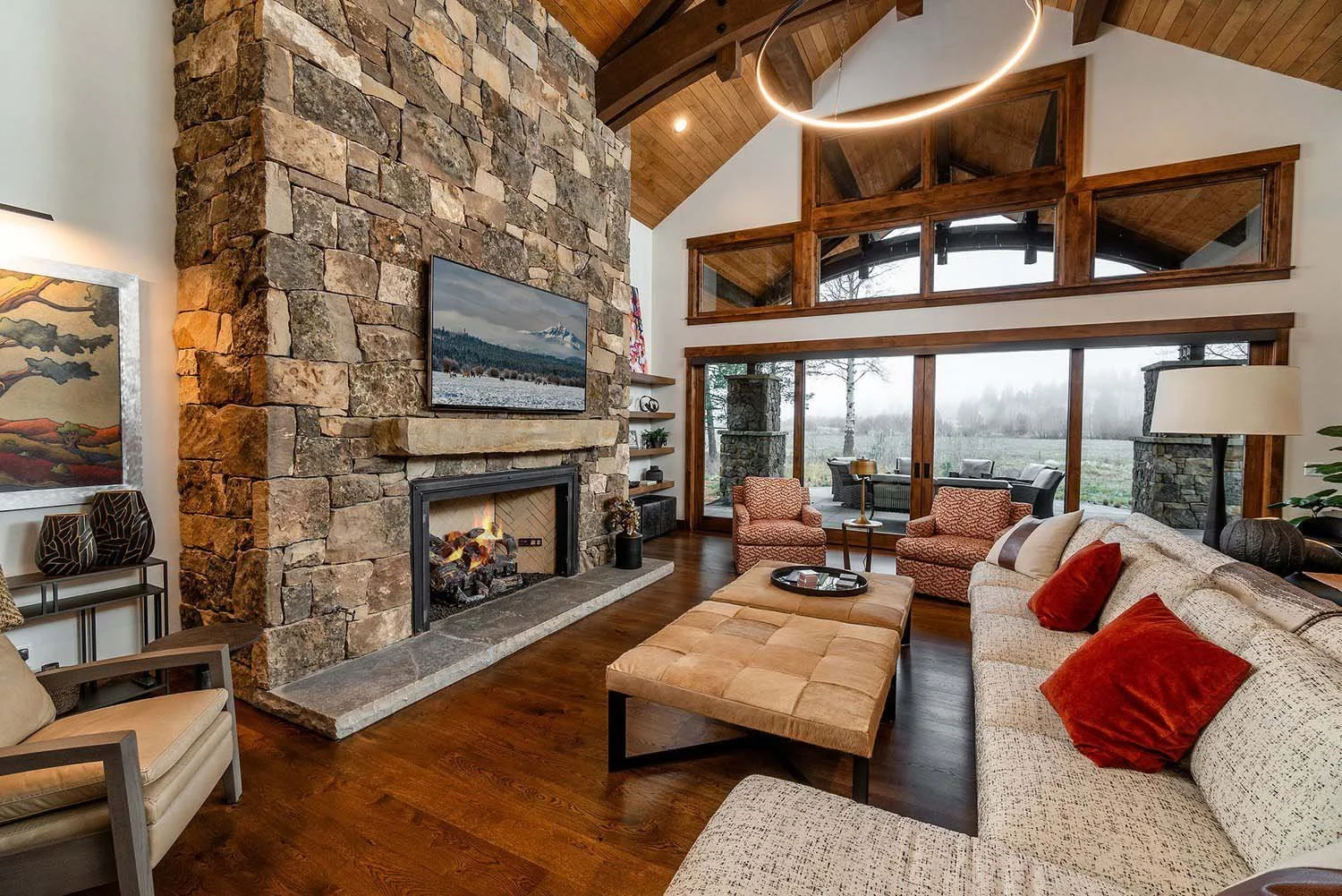 This luxurious outdoor patio at Black Butte Ranch - Bishops Cap is an ideal gathering spot for friends and family, expertly designed by Pacwest Builders. A central fireplace, surrounded by comfortable chairs, creates a warm and inviting atmosphere, a