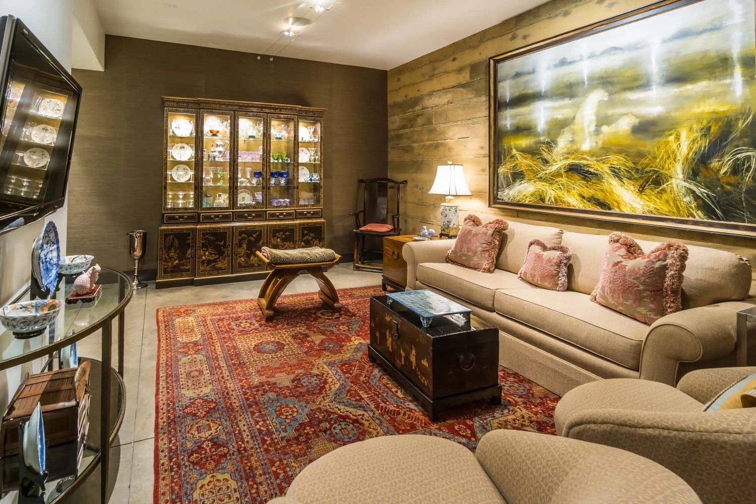 This inviting living room, a showcase in a luxury custom home built by Pacwest Builders with Hayes Inc. design in North Rim, offers a blend of comfort and curated style. The space also features a display cabinet with glass doors and a glass-topped t