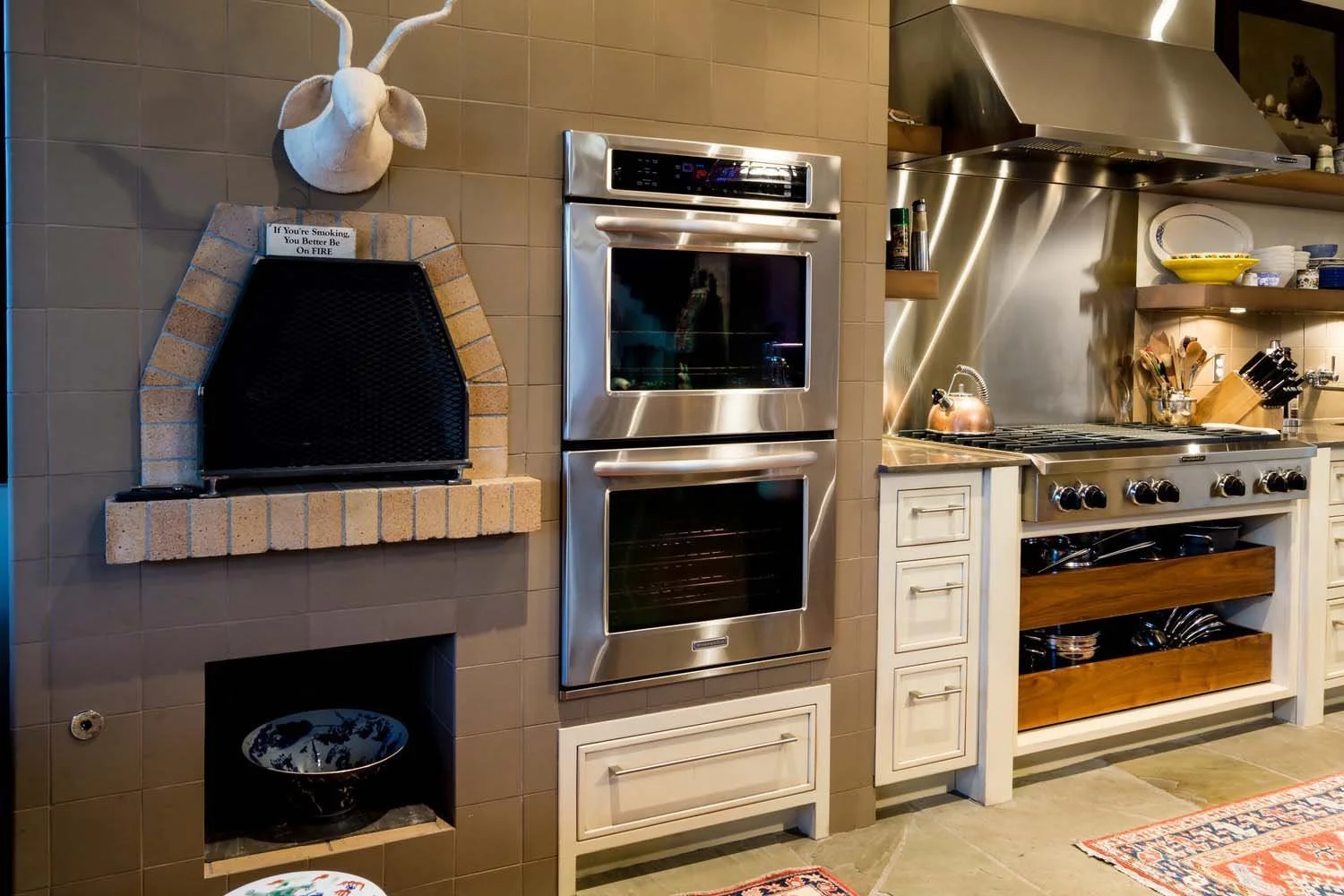 This unique kitchen, a focal point in a luxury custom home built by Pacwest Builders with Hayes Inc. design in North Rim, masterfully blends rustic charm with modern functionality. It features a sleek stainless steel double oven, pristine white cabin