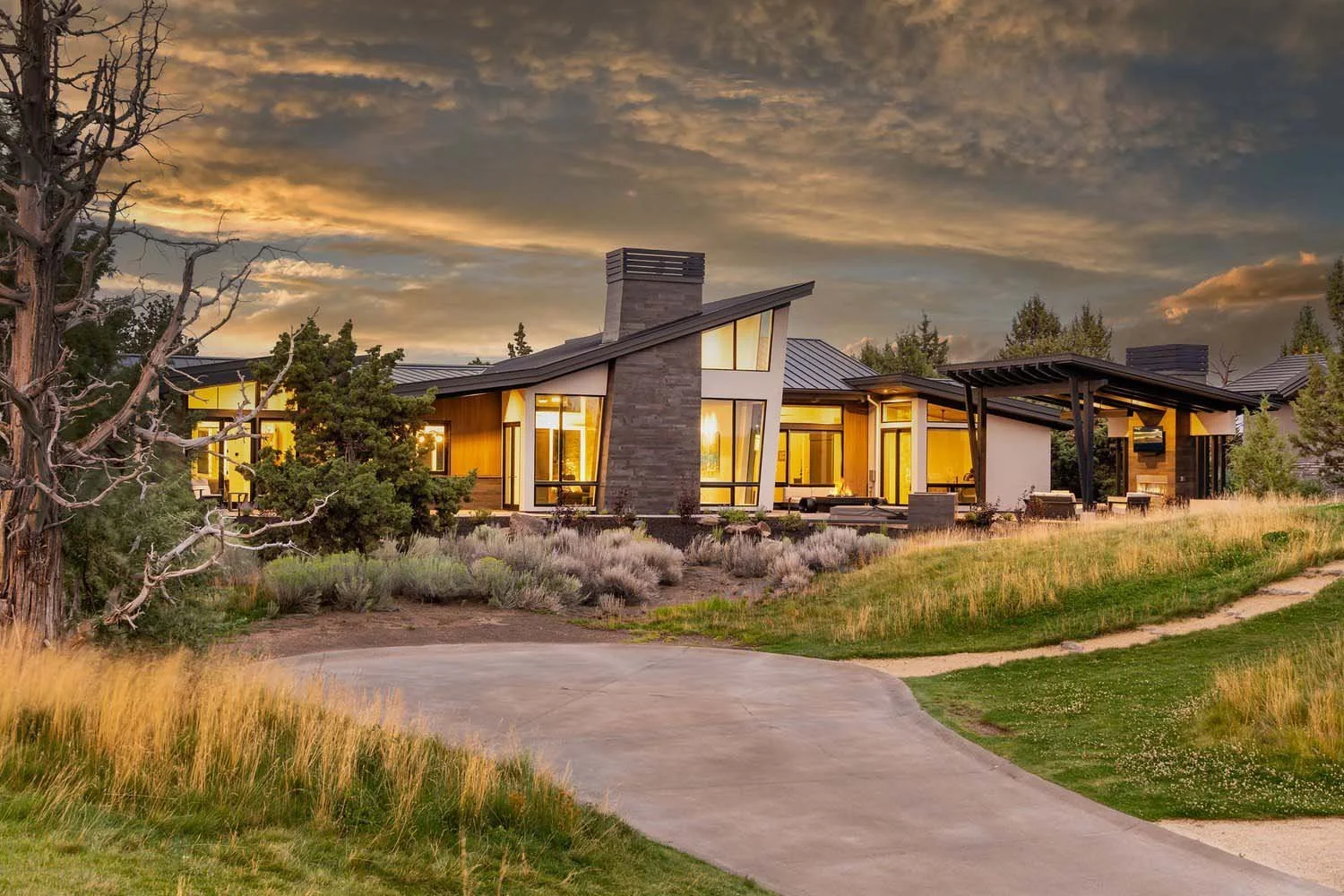 This inviting outdoor space at the Pronghorn - Canyon View home, designed by Blair Davis, is perfect for year-round enjoyment. The stunning brick chimney adds a classic touch to the covered patio, which is a perfect spot for unwinding. A convenient f
