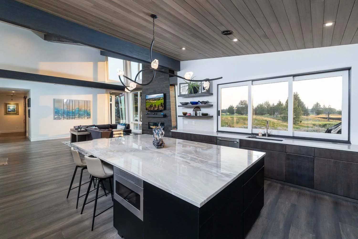 This breathtaking modern open-concept kitchen at Pronghorn - Canyon View is the ultimate space for cooking and entertaining. A magnificent large marble island with three comfortable barstools serves as the heart of the home, while elegant dark cabine