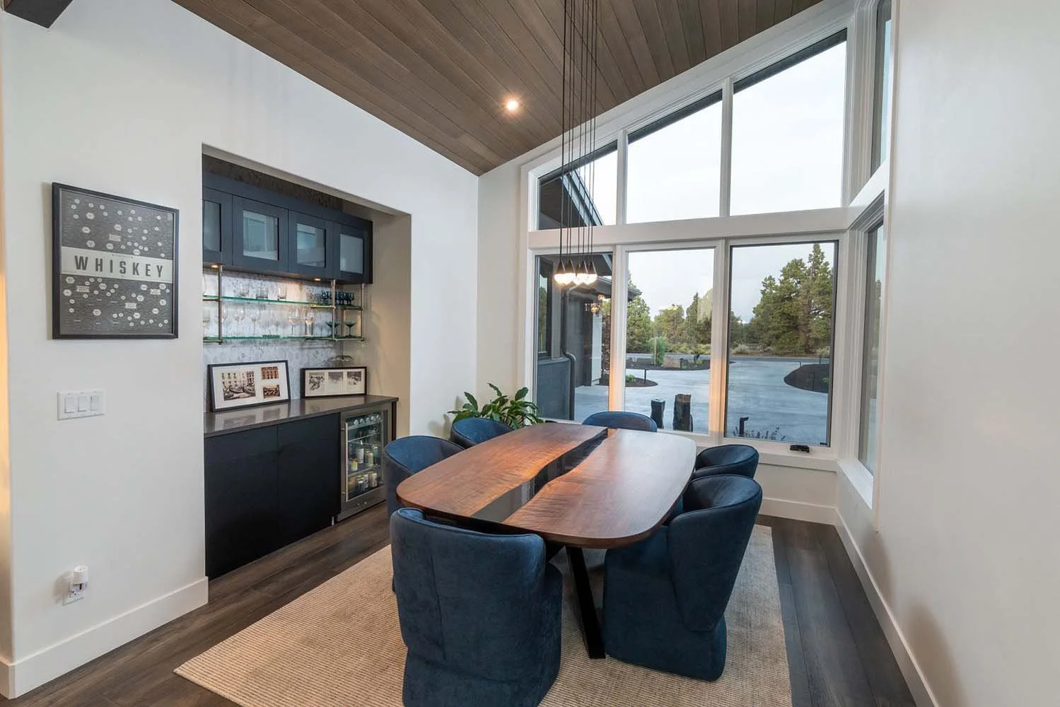This stunning dining room at Pronghorn - Canyon View, designed by Blair Davis, is the perfect space for gatherings and entertaining. The room features a magnificent large wooden table with six elegant blue chairs, all bathed in natural light from lar