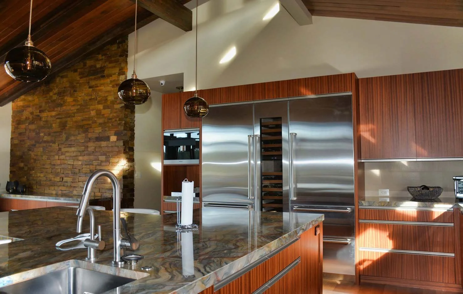 As experienced builders of luxury custom homes in Central Oregon, Pacwest Builders crafted this unique kitchen at North Rim - Wild Rye. The space, with interiors by Kristy Yozamp, is defined by its beautiful wooden cabinets and a sleek marble counter
