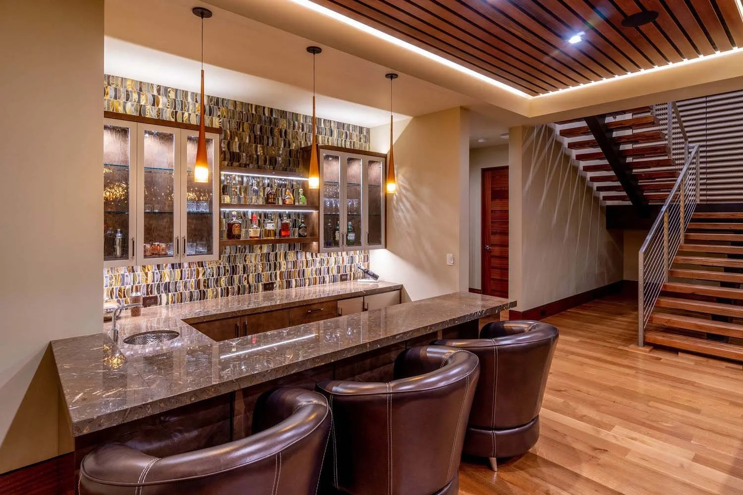 This sophisticated home bar area at the North Rim - Wild Rye home by Pacwest Builders is designed for comfortable and stylish entertaining. The space features a sleek marble countertop and elegant leather chairs, creating a luxurious and inviting atm