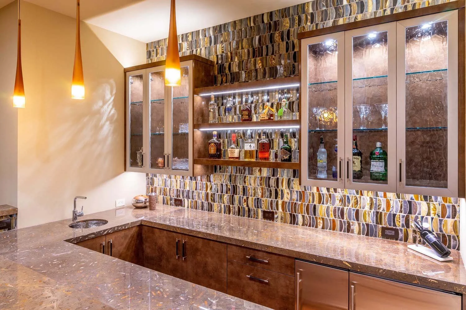 As experienced builders of luxury custom homes in Central Oregon, Pacwest Builders crafted this unique entertaining space at North Rim - Wild Rye. This image, with interiors by Kristy Yozamp, highlights a stunning home bar with a polished marble coun