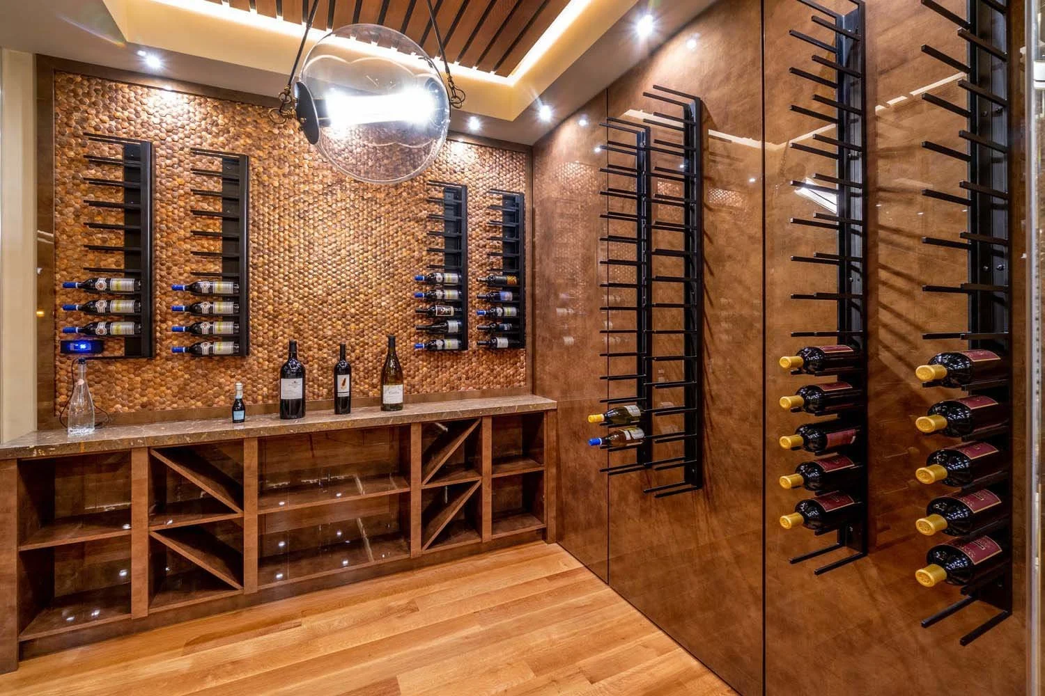 This stunning wine cellar at the North Rim - Wild Rye home by Pacwest Builders is a perfect blend of style and function. The space, with its elegant wooden walls and floors and multiple wine racks, is a wine lover's dream. A custom decorative wall wi