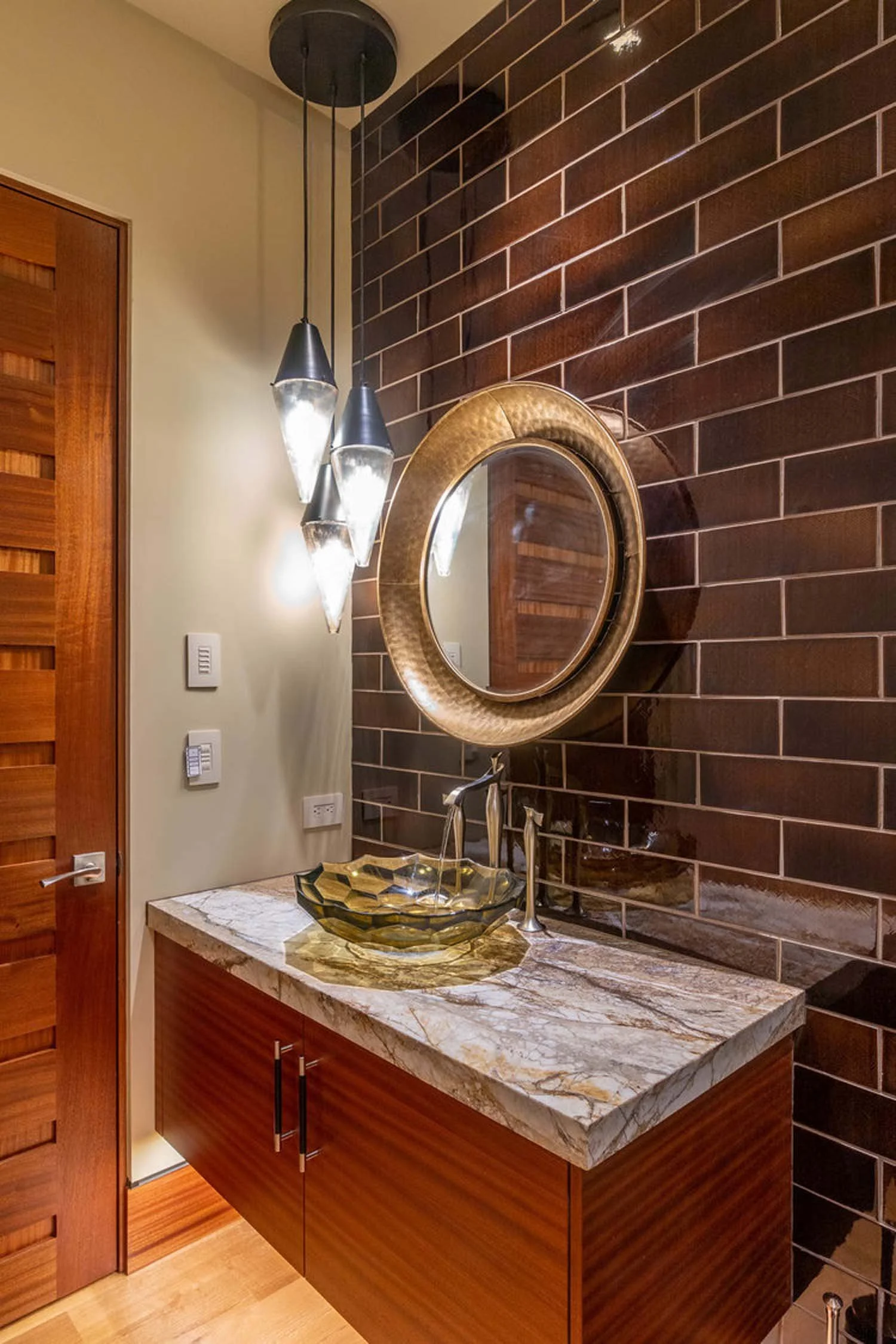 This elegant bathroom vanity at the North Rim - Wild Rye home by Pacwest Builders is a perfect blend of modern and natural materials. The space features a sleek marble countertop and a standout honeycomb-patterned glass vessel sink, a unique work of