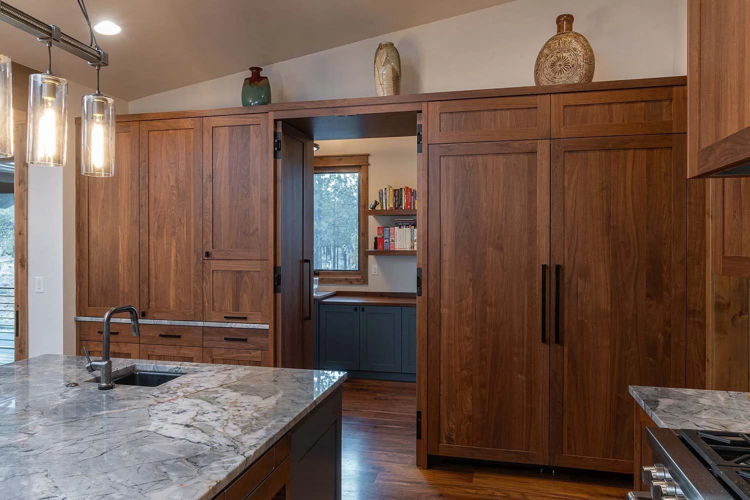 As experienced builders of luxury custom homes in Central Oregon, Pacwest Builders crafted this unique kitchen at Skyline Ranch - Imbler. The space, with interiors by Kate Dardin, is defined by its elegant wooden cabinets and a stunning marble island