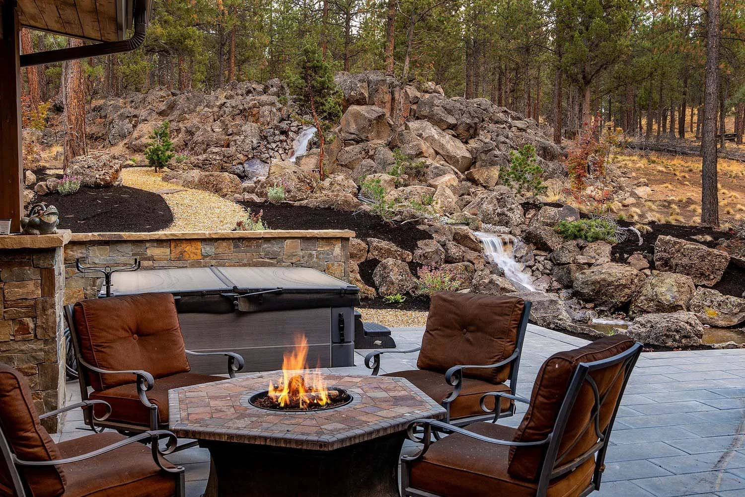 This stunning outdoor patio at Skyline Ranch - Imbler, designed for a couple who love to entertain, is the perfect spot for relaxation. The space features a cozy fire pit surrounded by four comfortable brown cushioned chairs, creating a perfect gathe