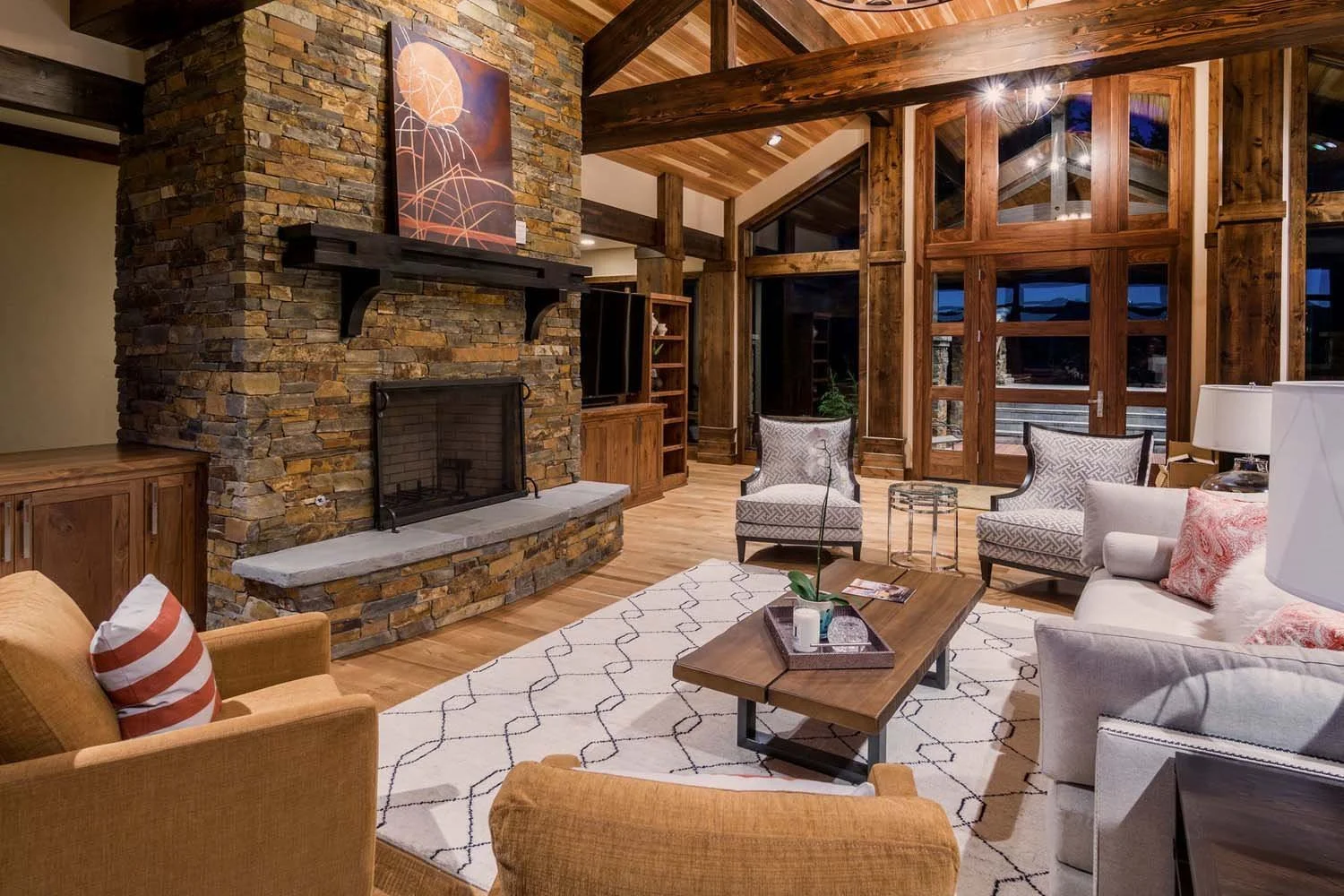 As experienced builders of luxury custom homes in Central Oregon, Pacwest Builders crafted this award-winning living room at North Rim - Wild Rye. The space, with interiors by Kristy Yozamp, features a grand stone fireplace and beautiful wooden beams