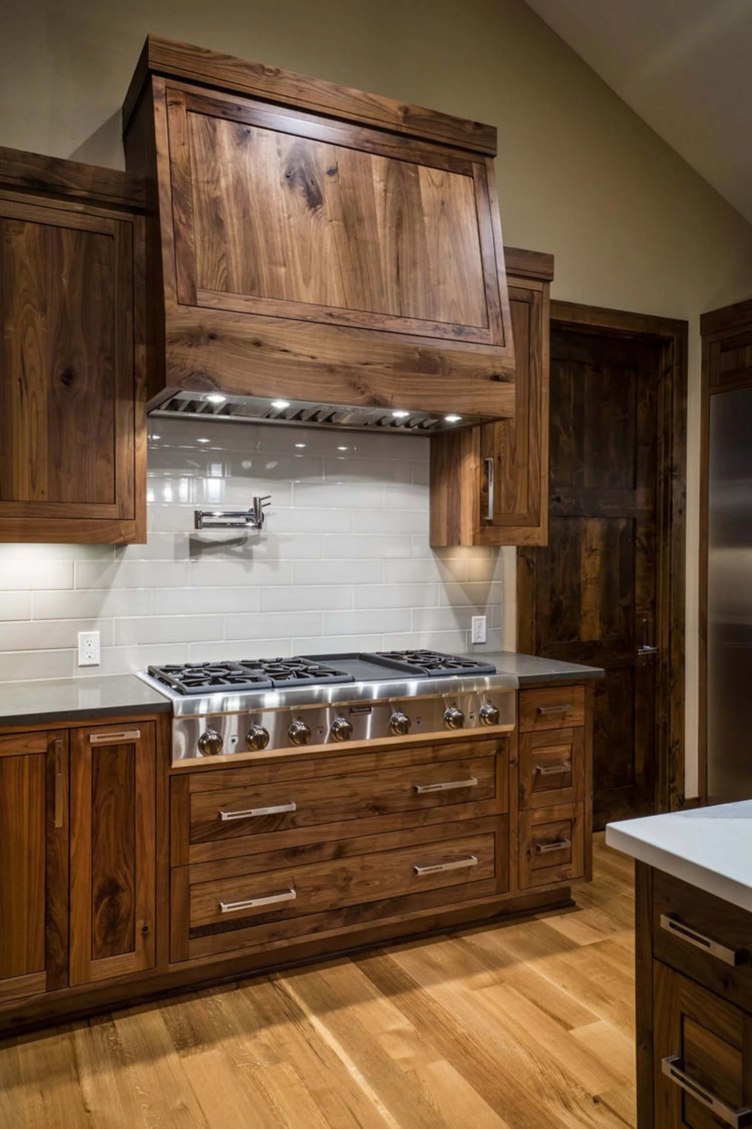 This stunning kitchen in the award-winning North Rim - Wild Rye home is a testament to sophisticated design and functionality. The space features elegant wooden cabinets that complement the sleek stainless steel stove, a hallmark of a high-end, chef-
