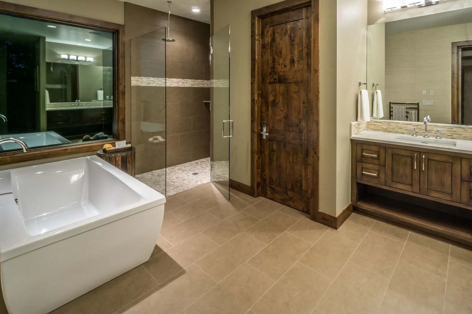 As experienced builders of luxury custom homes in Central Oregon, Pacwest Builders crafted this award-winning bathroom at North Rim - Wild Rye. This space, with interiors by Kristy Yozamp, highlights a stunning glass shower enclosure and a freestandi