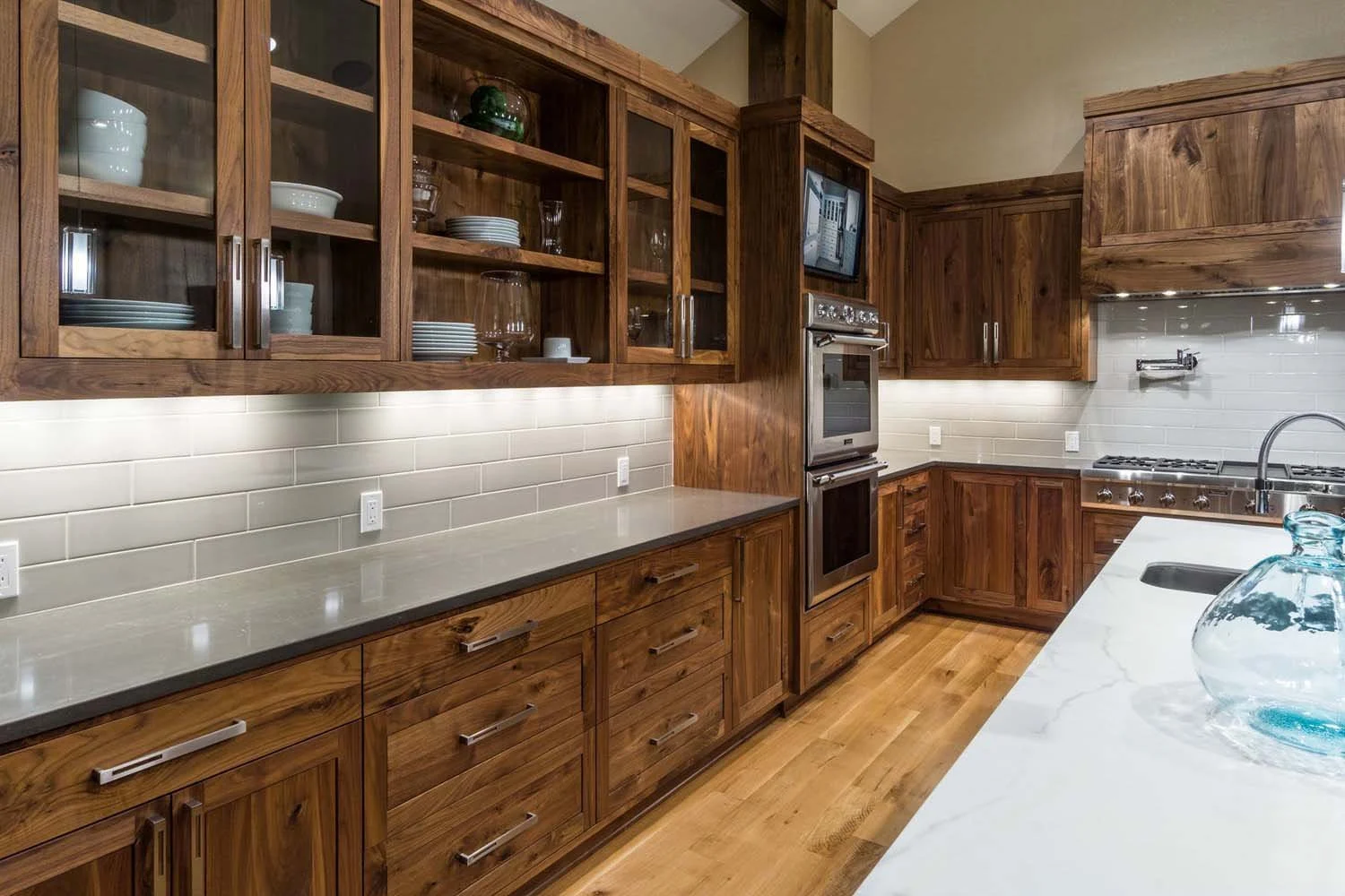 As experienced builders of luxury custom homes in Central Oregon, Pacwest Builders crafted this award-winning kitchen at North Rim - Wild Rye. This space, with interiors by Kristy Yozamp, features beautiful wooden cabinets, a sleek white countertop,