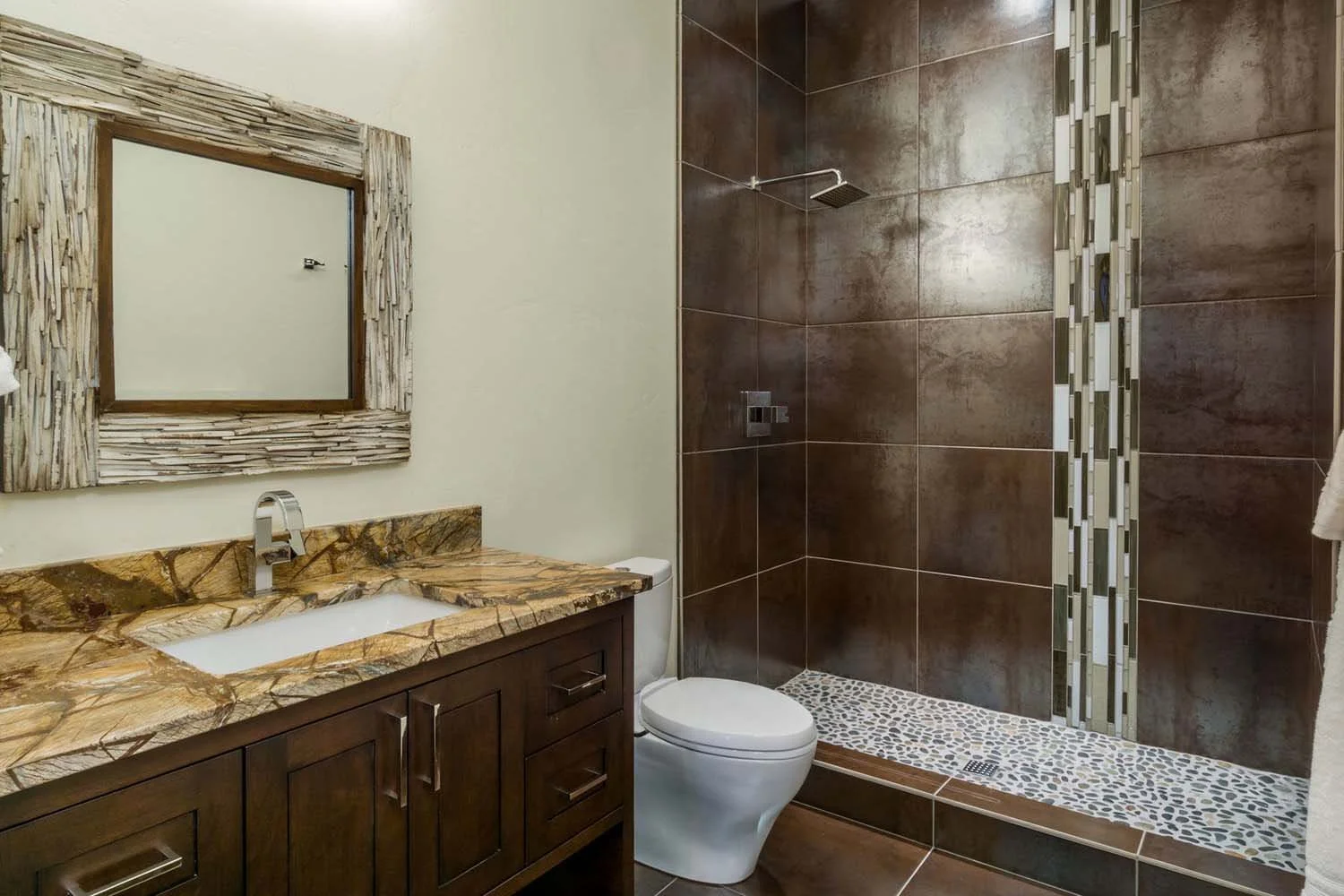 As experienced builders of luxury custom homes in Central Oregon, Pacwest Builders crafted this award-winning bathroom at North Rim - Wild Rye. This space, with interiors by Kristy Yozamp, highlights a stunning walk-in shower with a unique pebble flo