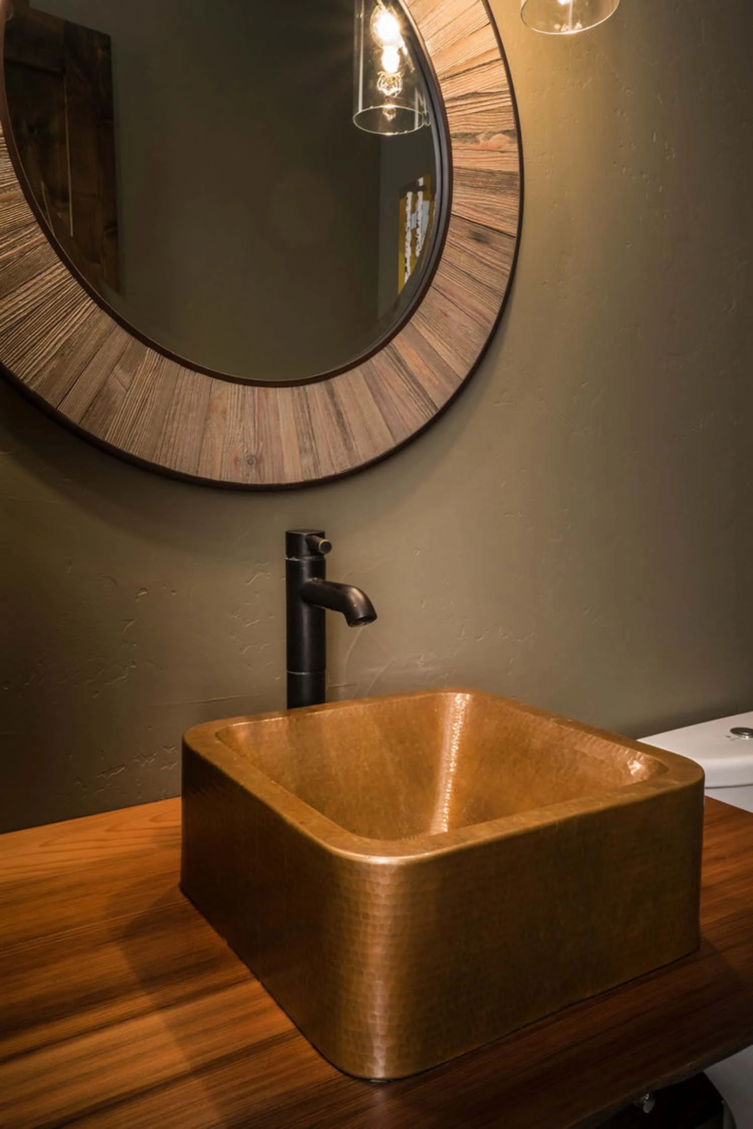 As experienced builders of luxury custom homes in Central Oregon, Pacwest Builders crafted this award-winning bathroom at North Rim - Wild Rye. This image, with interiors by Kristy Yozamp, highlights a one-of-a-kind copper vessel sink and a modern bl