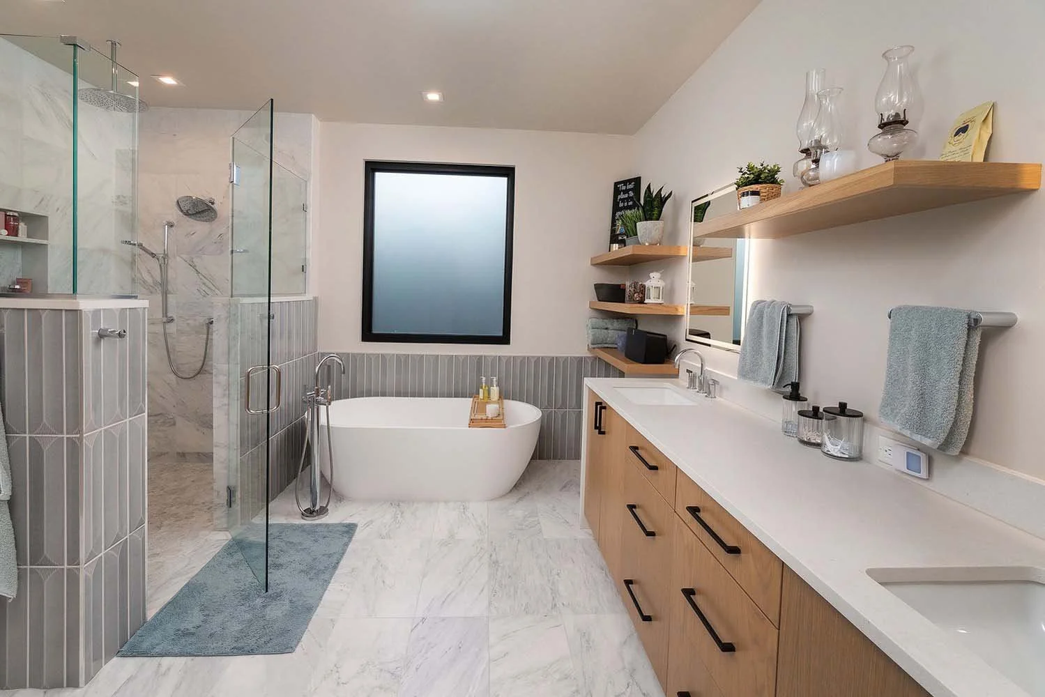 This stunning bathroom at the Tetherow - Hardin Martin Court home by Pacwest Builders is a perfect blend of style and a tranquil connection to nature. The space features a custom walk-in shower with glass doors, a luxurious freestanding bathtub, and