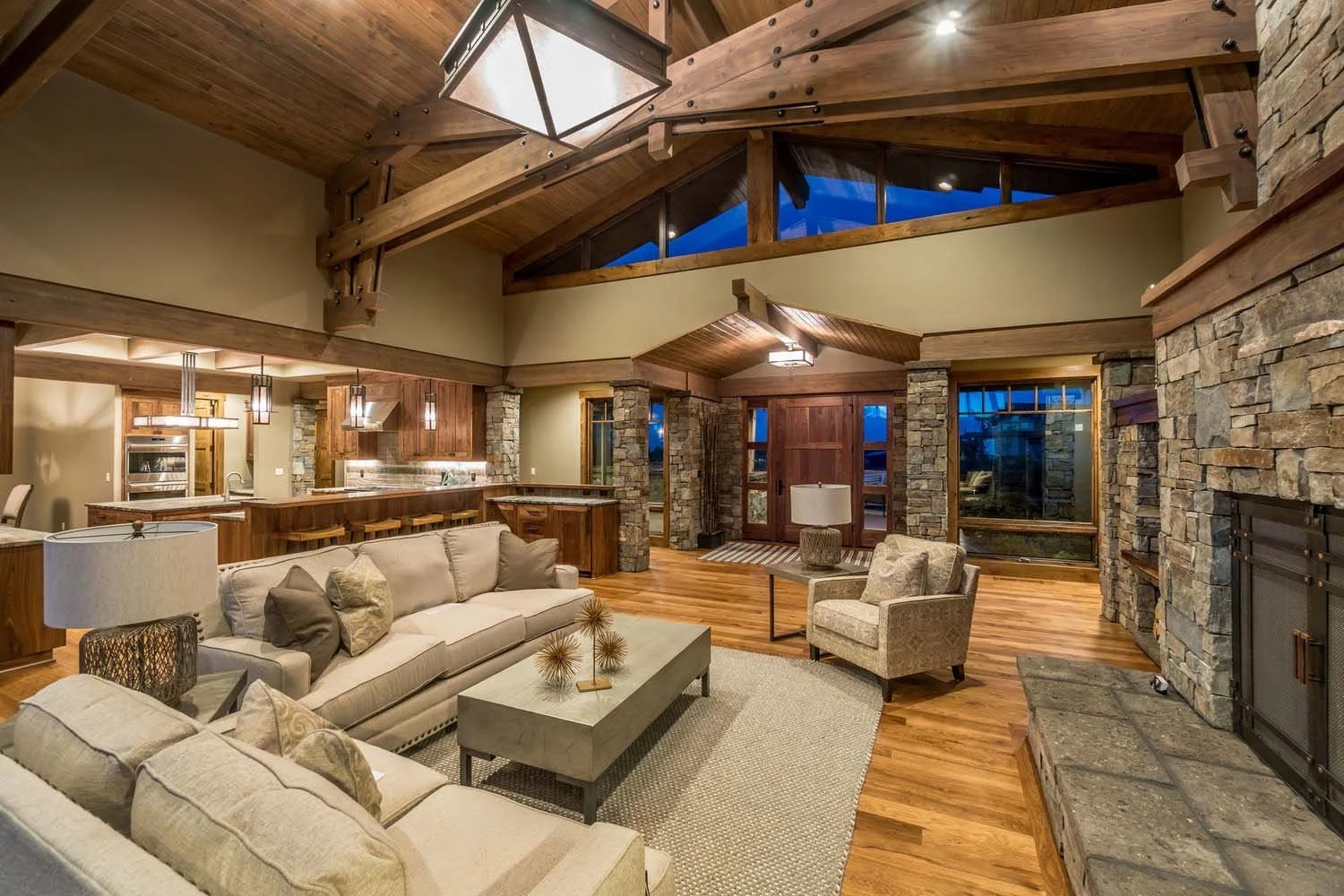 As experienced builders of luxury custom homes in Central Oregon, Pacwest Builders crafted this unique living space at Tetherow - Hawk Court. The space, with interiors by Kristy Yozamp, highlights a striking stone fireplace, a beautiful wooden ceilin